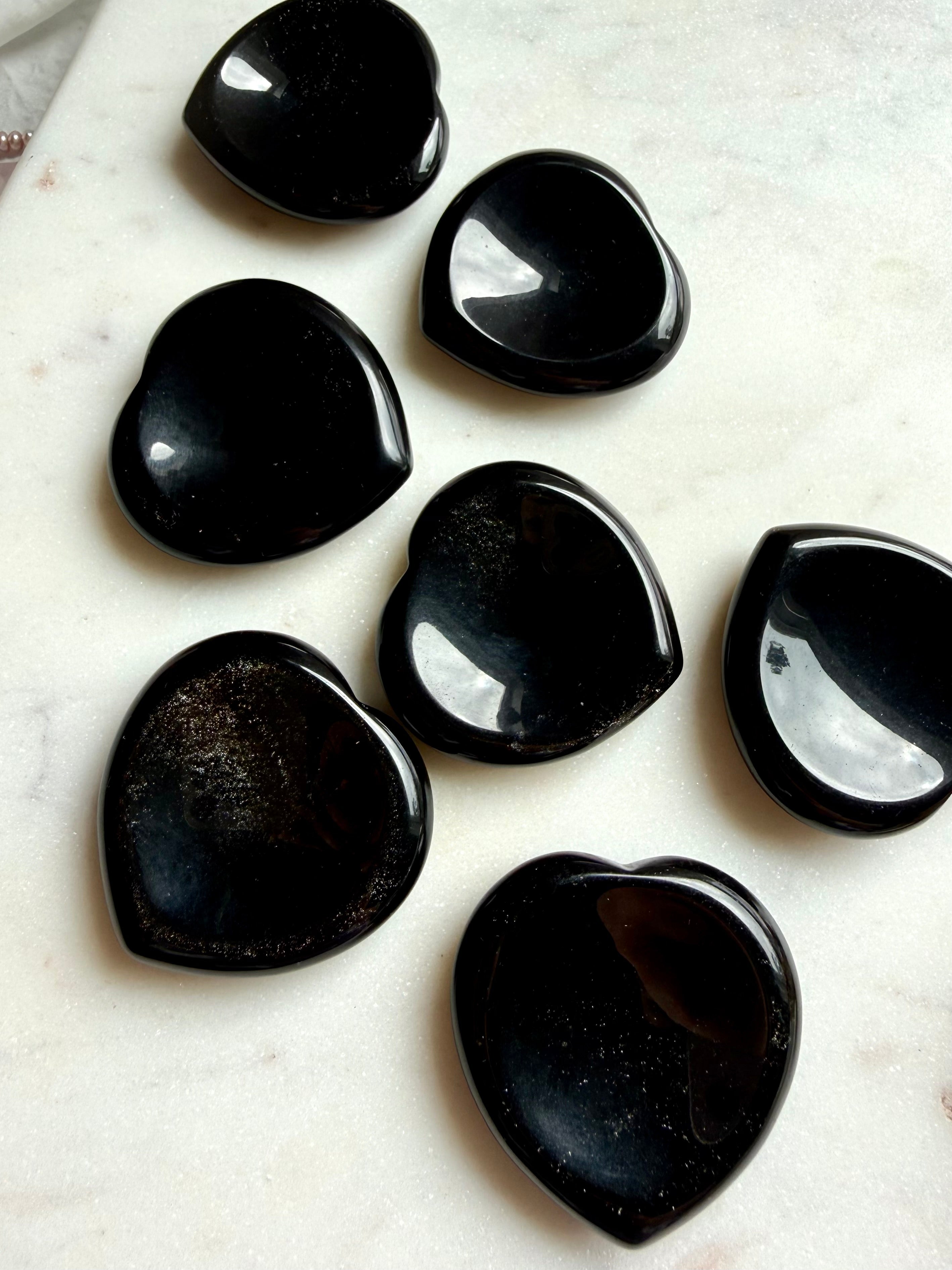 sheen obsidian heart crystals grouped on marble surface for energy clearing and grounding support