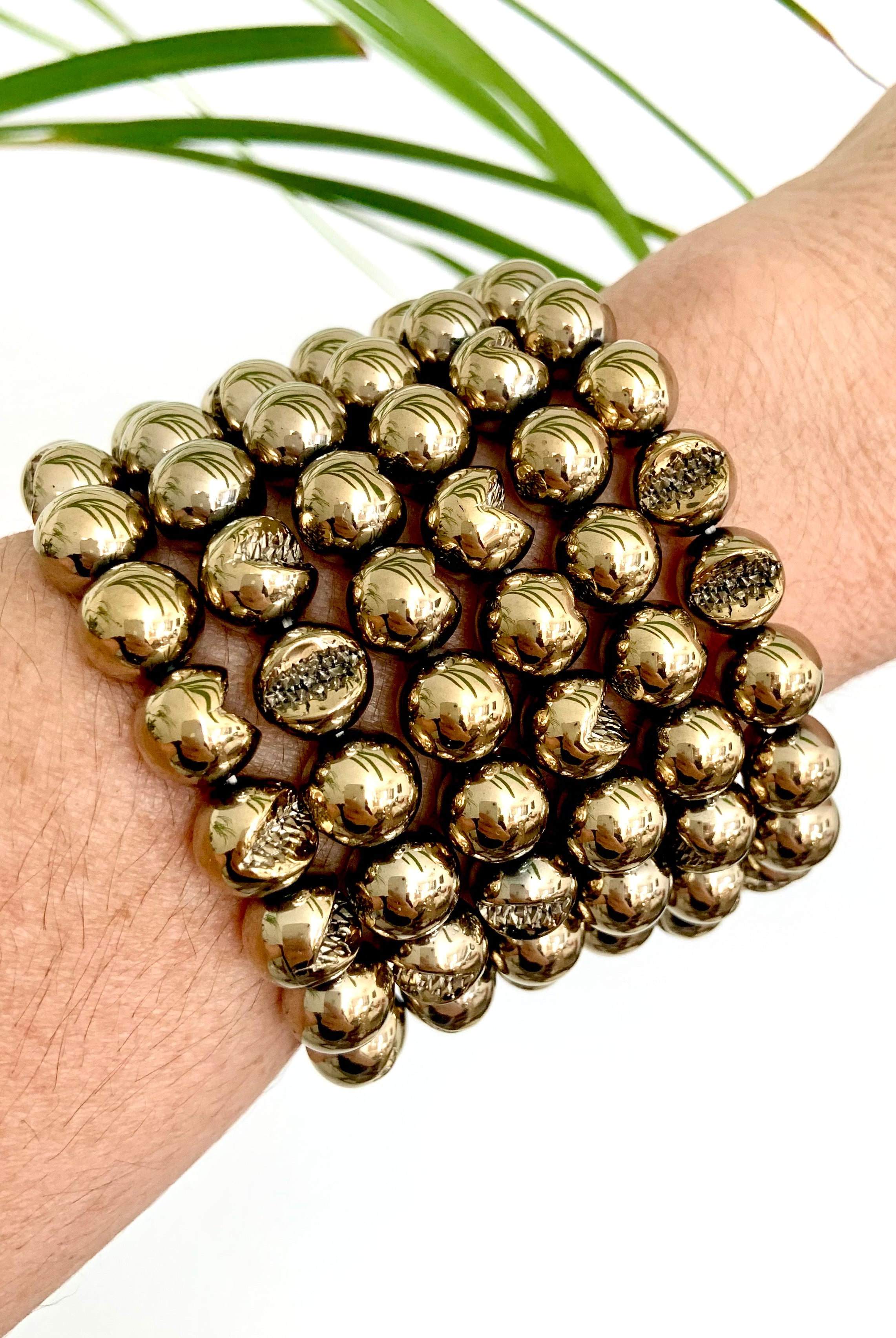 Stack of Pyrite crystal bracelets worn on wrist — grounding & protective stone of abundance, confidence & personal power.