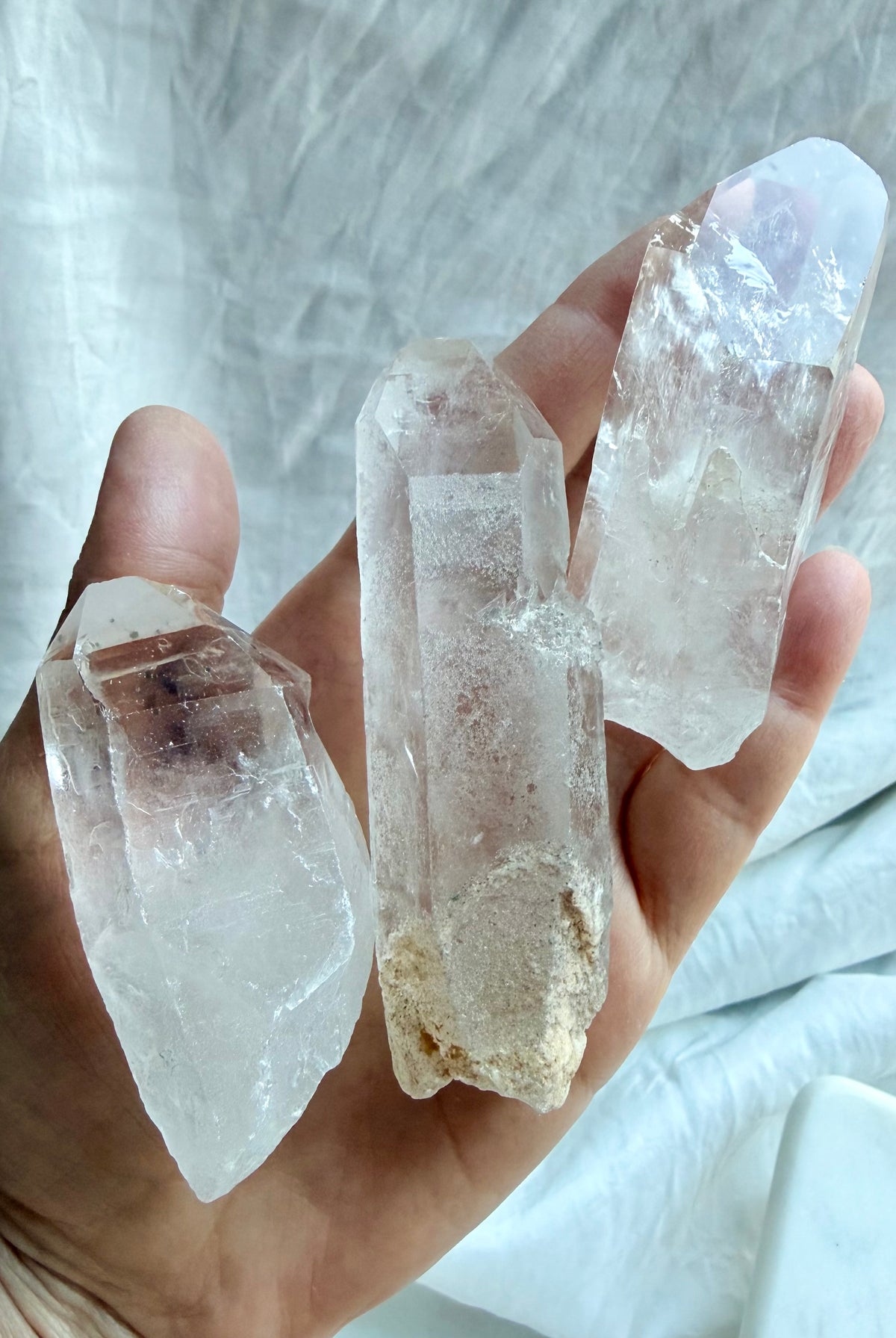Large Lemurian Quartz point held in hand showing chunky natural formation, clear and cloudy Quartz, and rough surfaces