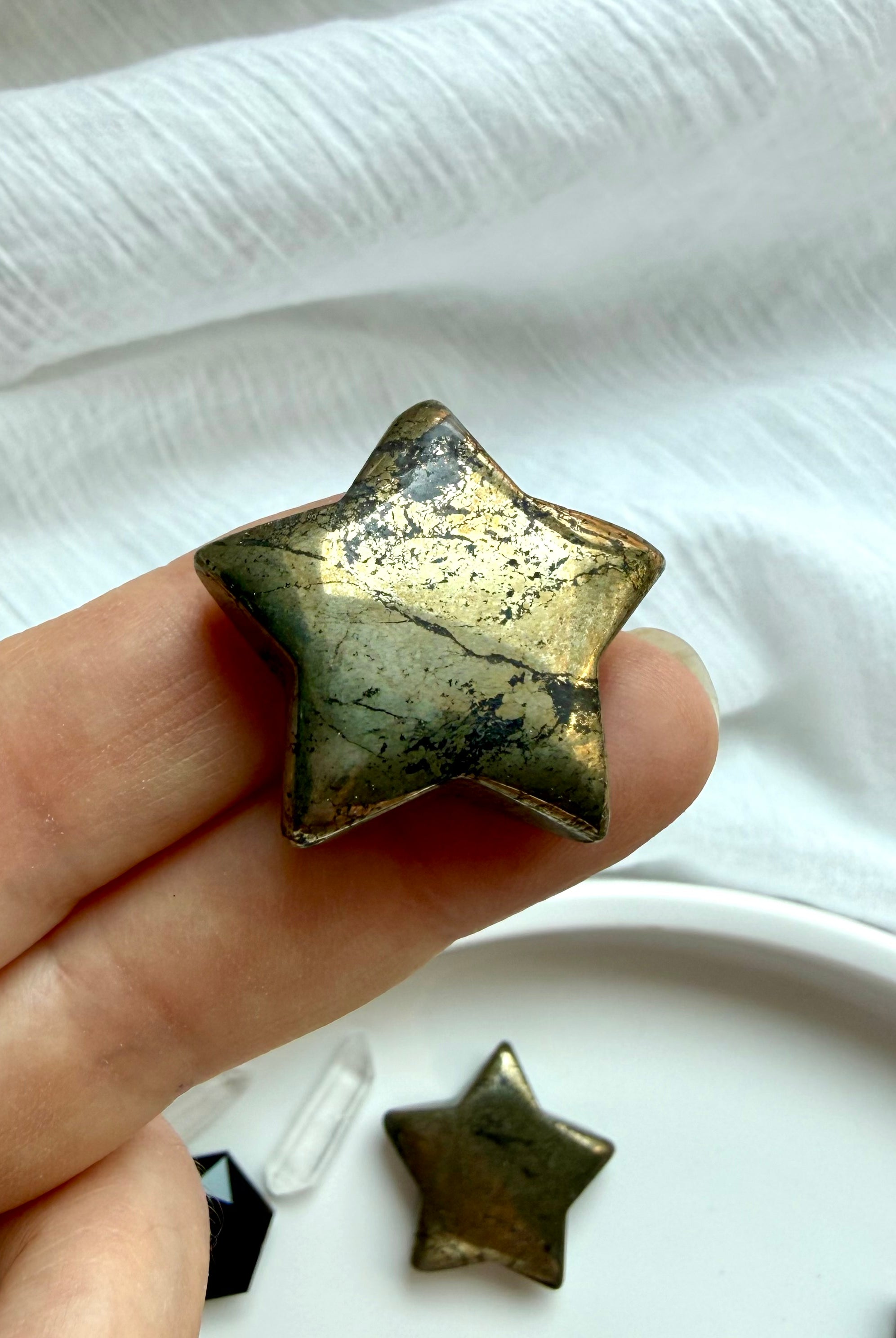 Close-up of polished Pyrite star carving with sparkling metallic texture and natural golden-bronze luster