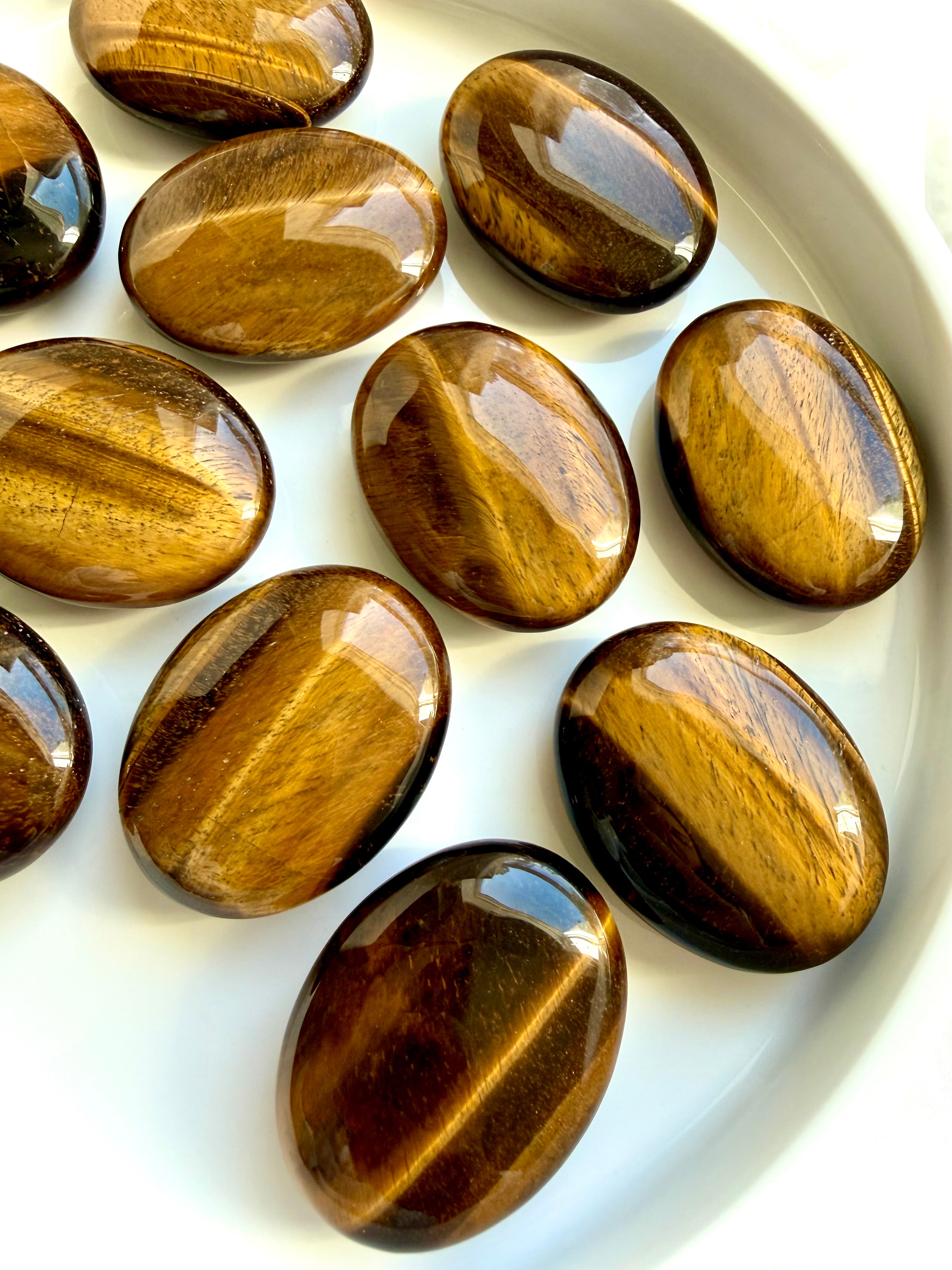 Tiger’s Eye palm stones with golden chatoyancy and silky bands of light for confidence, protection, and personal power
