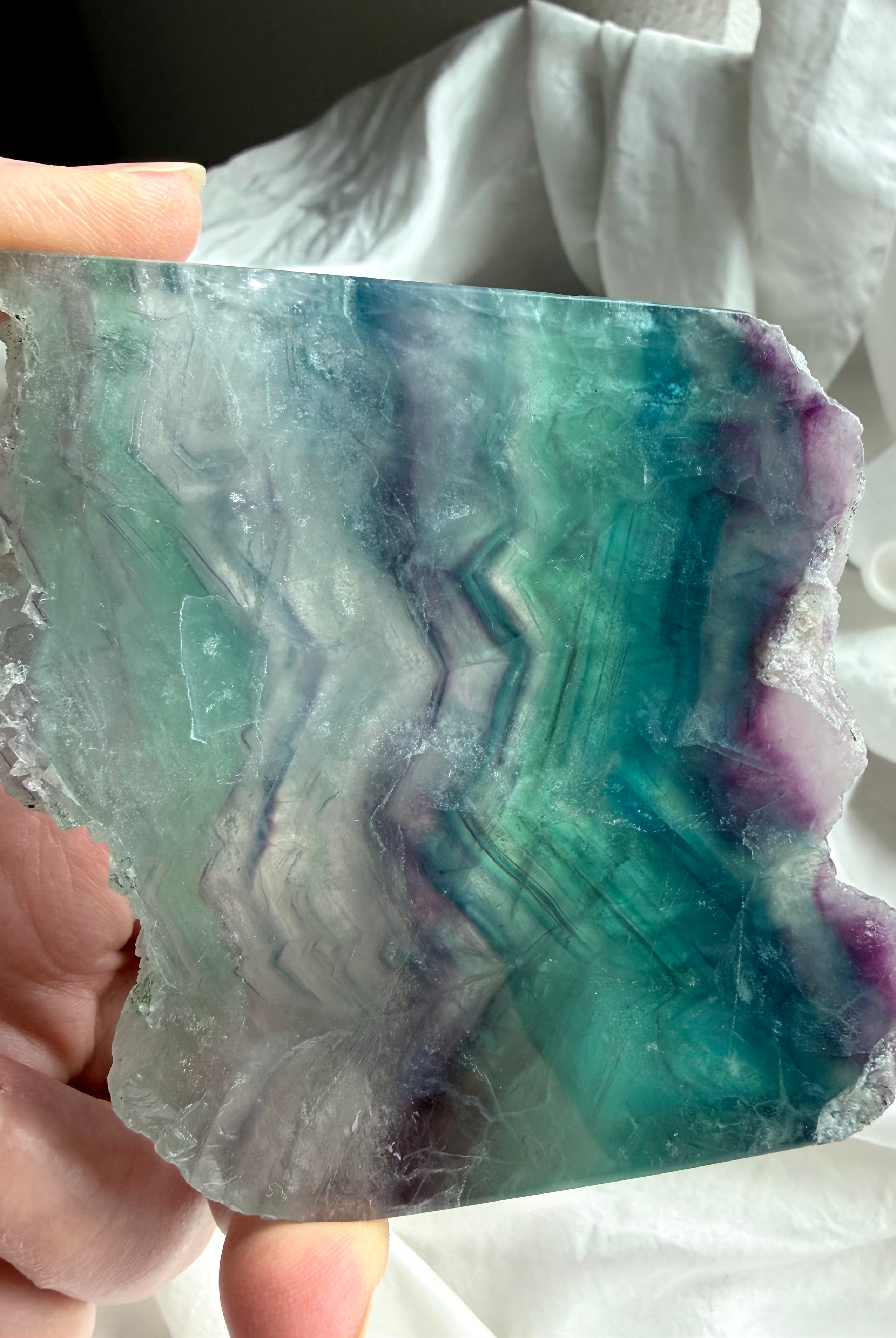 Polished fluorite slab photographed in natural light highlighting teal and purple crystal banding
