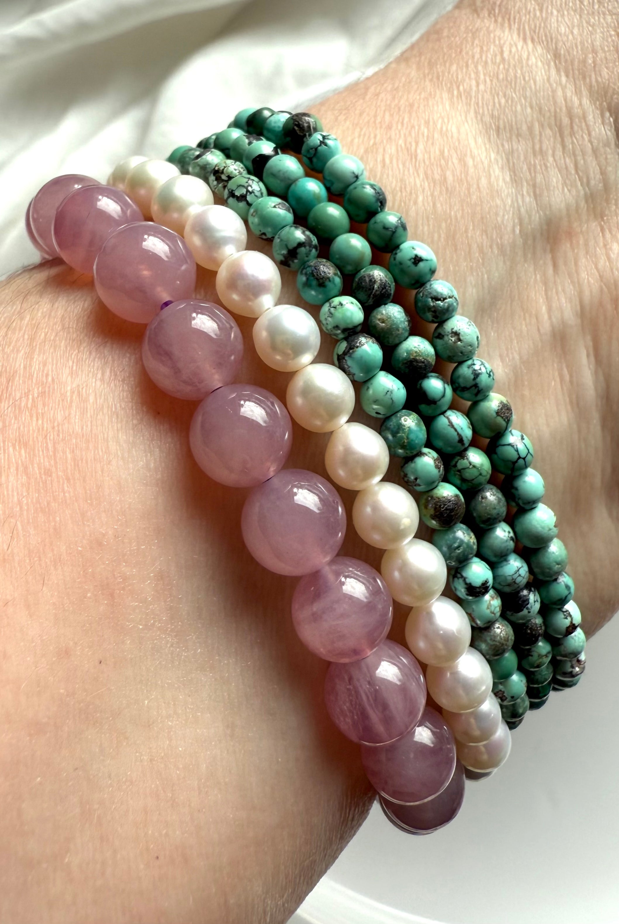 Crystal bracelet stack with lavender rose quartz, pearl, and turquoise for love, peace + heart chakra healing