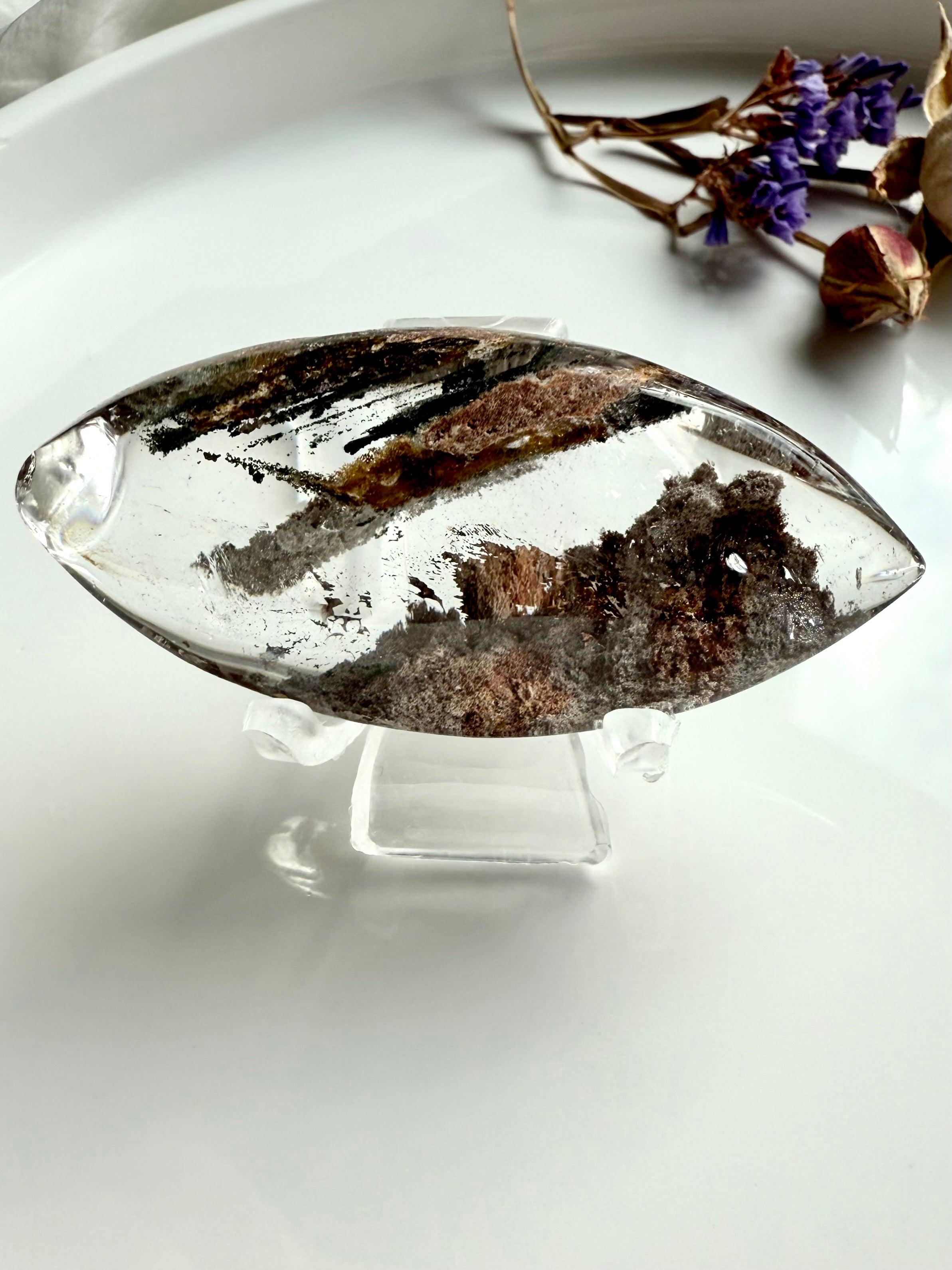 One of a kind Garden Quartz marquise lens displayed on clear stand with forest-like inclusions