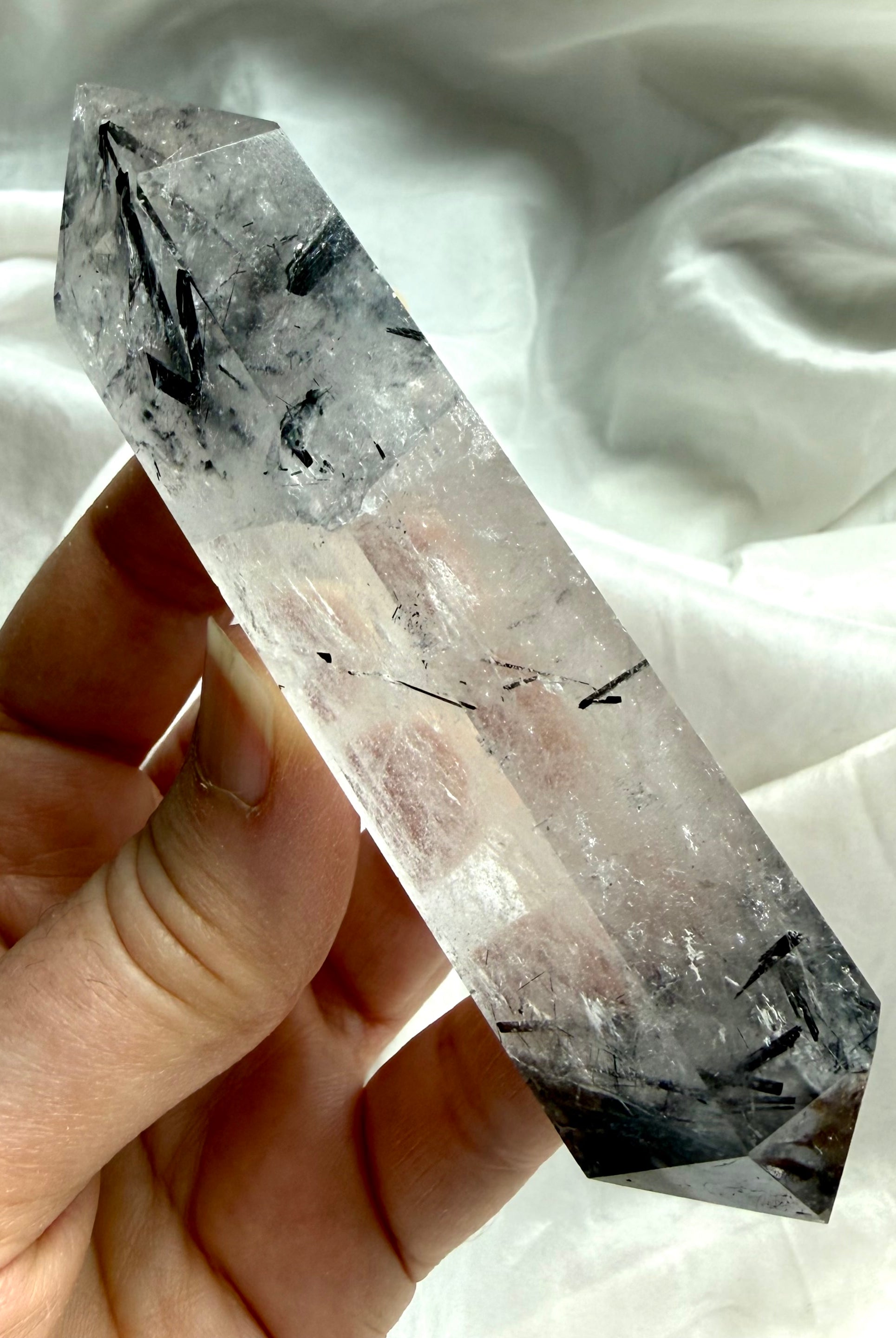 black tourmaline in quartz DT crystal held in hand for size reference