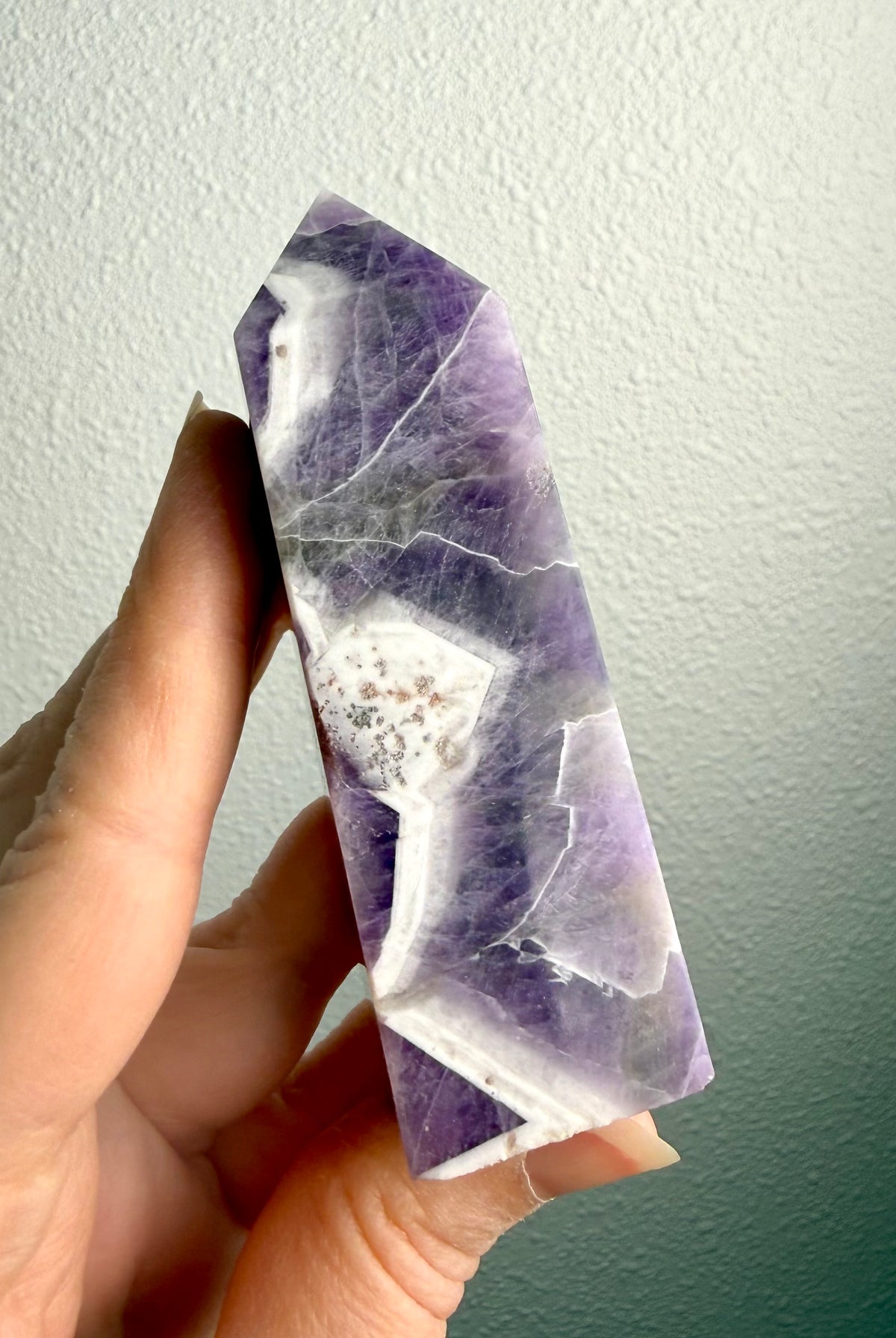 Dream Amethyst tower crystal with striking purple and white Chevron Amethyst banding, polished six-sided point and natural quartz patterns