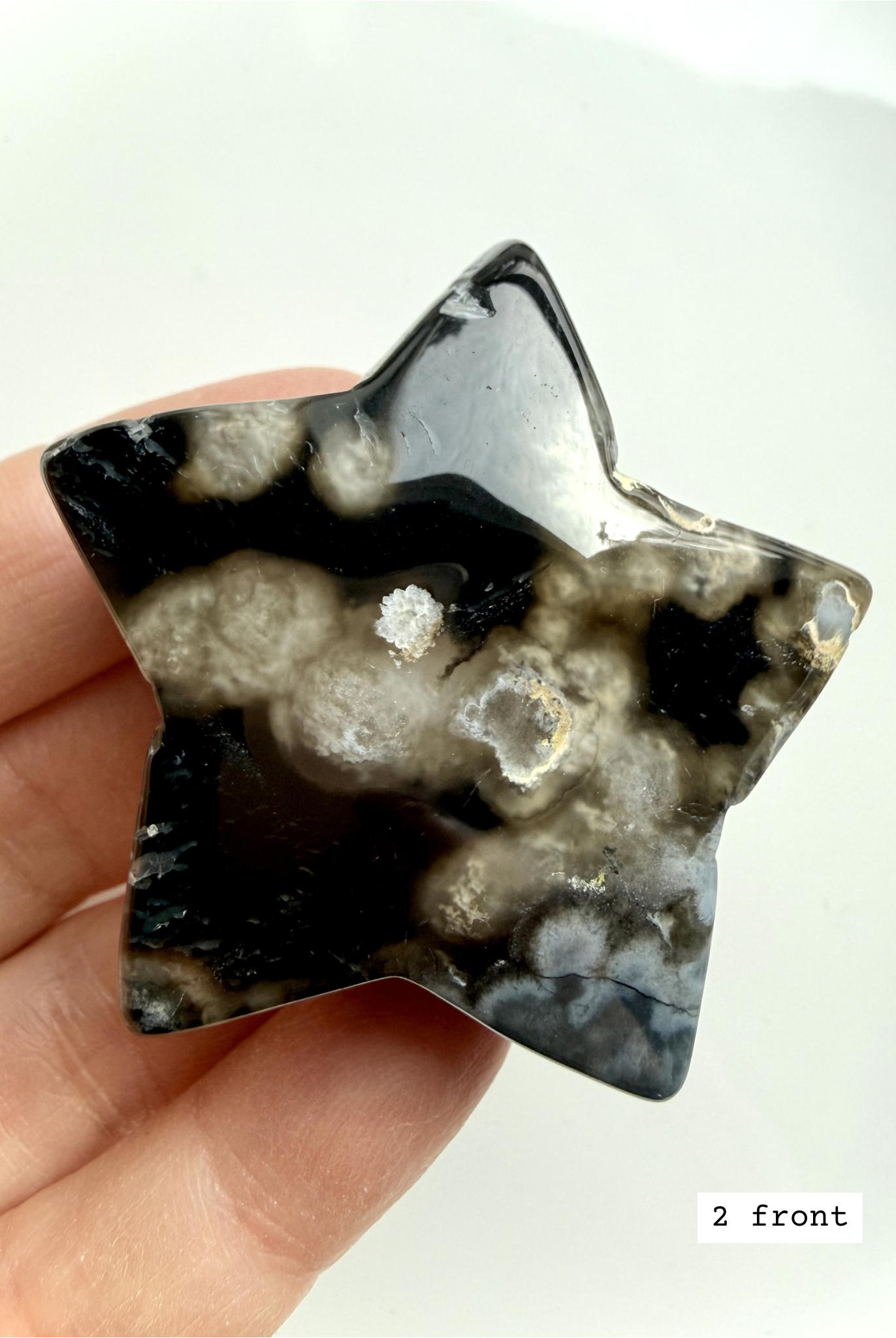 black flower agate star carving #2 front showing white floral plume patterns and polished finish
