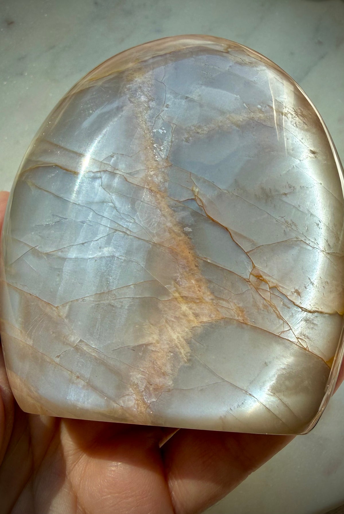 Peach Moonstone freeform held in hand with luminous silver Moonstone shimmer, crystal for intuition and Sacral Chakra energy
