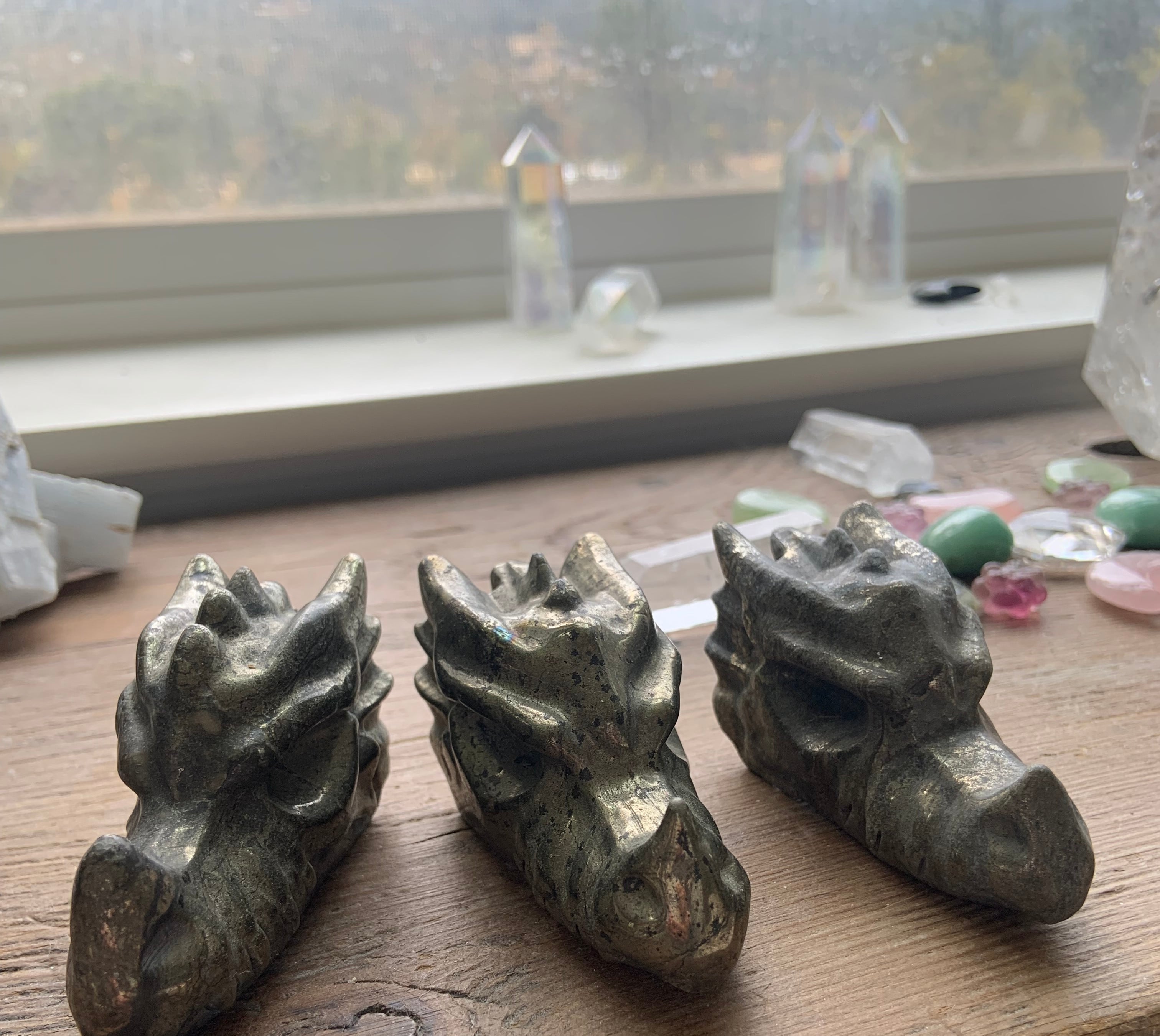 Pyrite dragon crystal carvings lined up on wooden altar, intuitively chosen protection stones