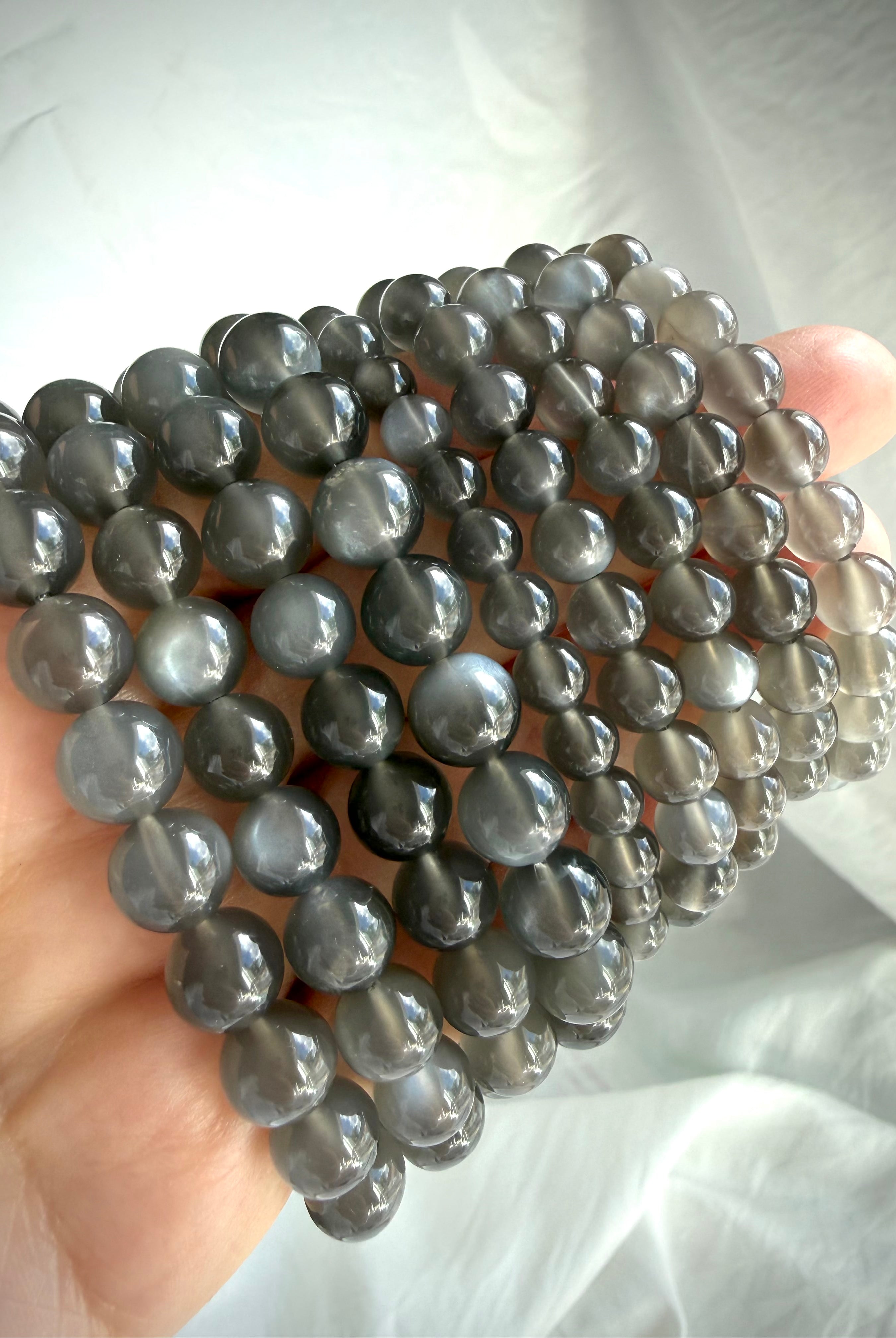 Black Moonstone bracelets in multiple bead sizes with moonlit shimmer, adularescence, and translucent charcoal gray tones