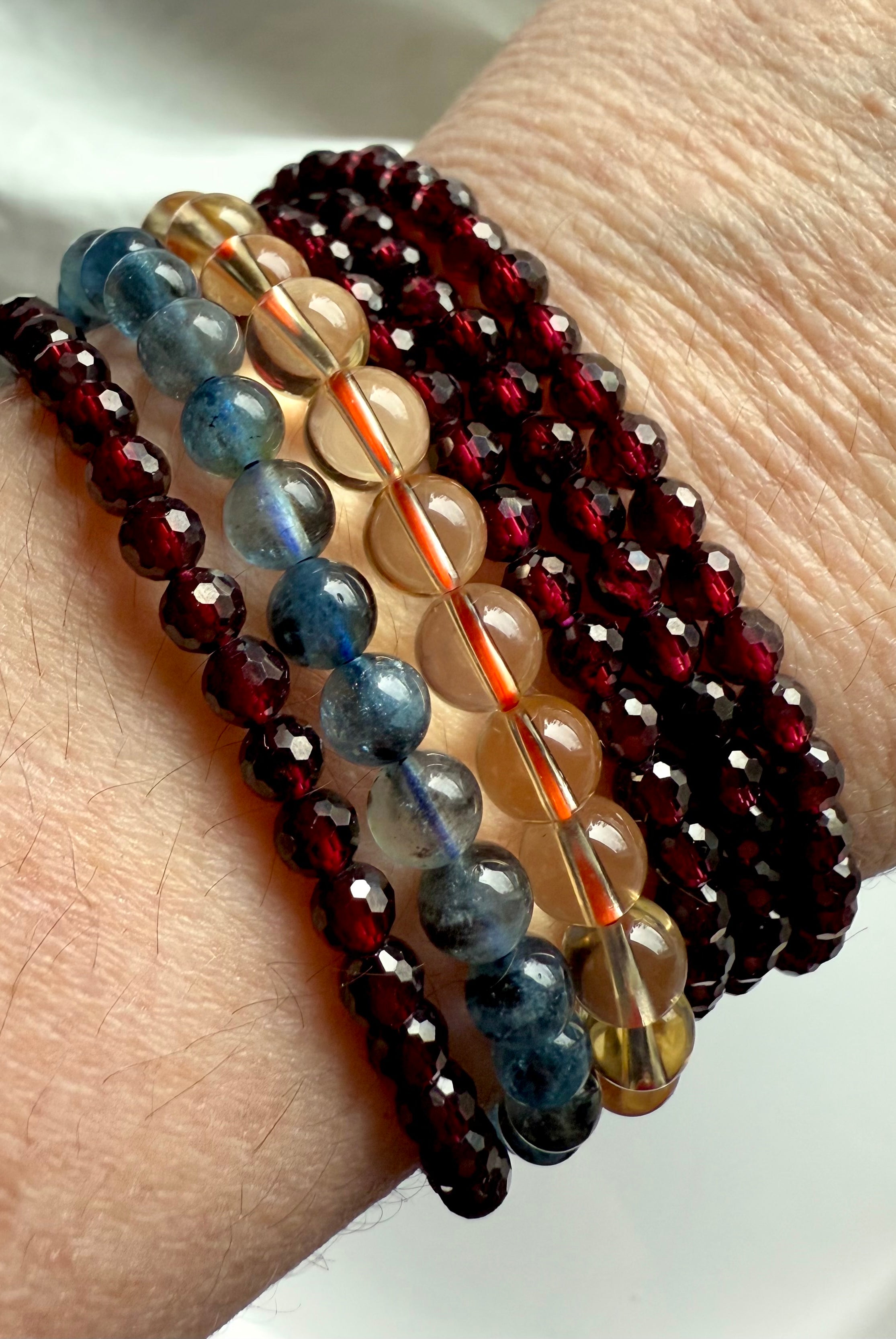 Showing both options of our faceted Red Garnet bracelets worn with Natural Citrine + Aquamarine