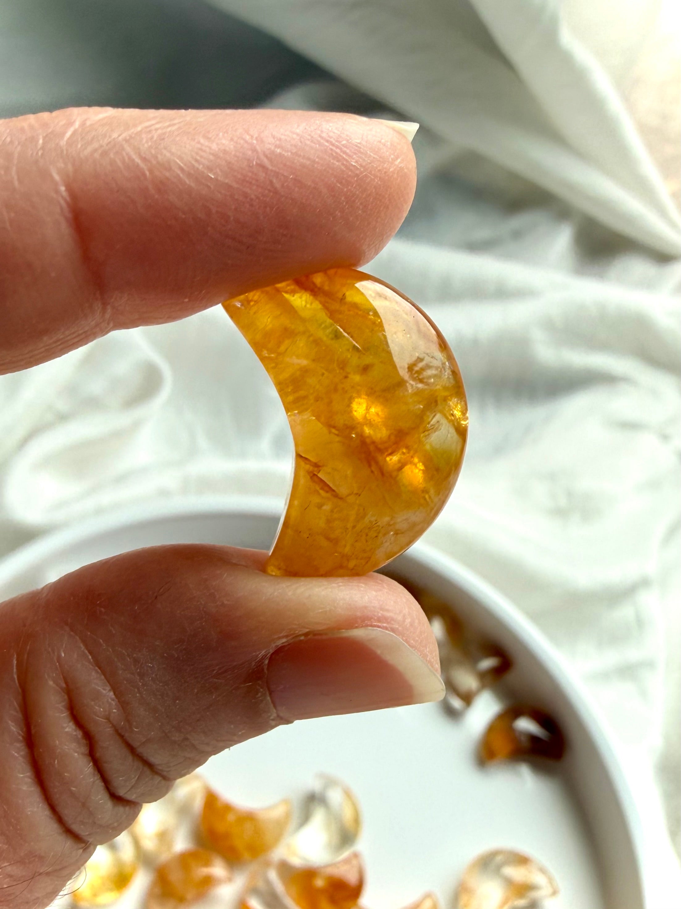 Golden Healer Quartz moon carving close up with golden Hematoid inclusions and smooth polished finish