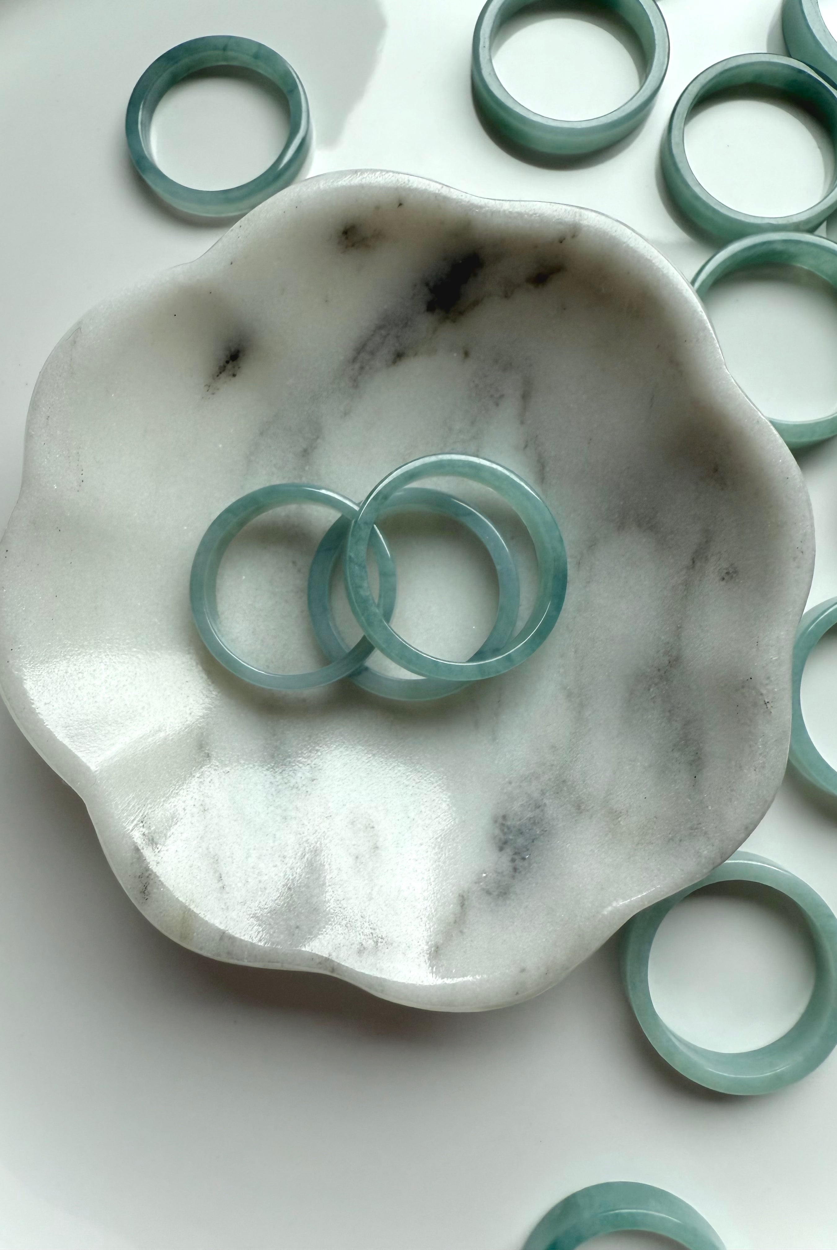Blue Water Jade rings on a marble flower dish with soft green-blue hues and natural texture