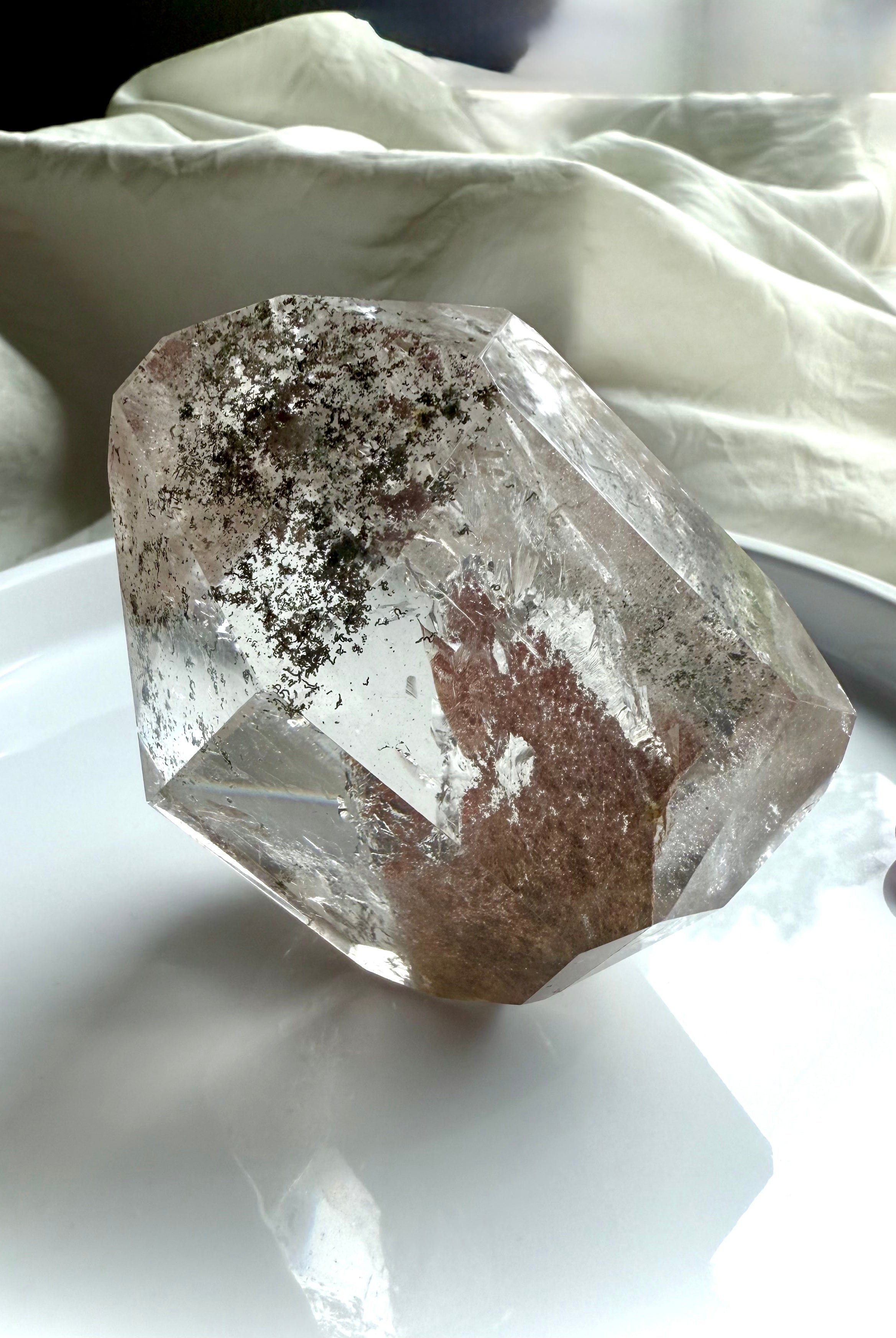 A Lodolite Garden Quartz Crystal shown standing on one of the side angles to highlight the phantom