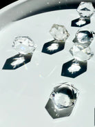 Angled view of multiple Clear Quartz hexagons standing on edges, casting radiant hexagonal light and shadows