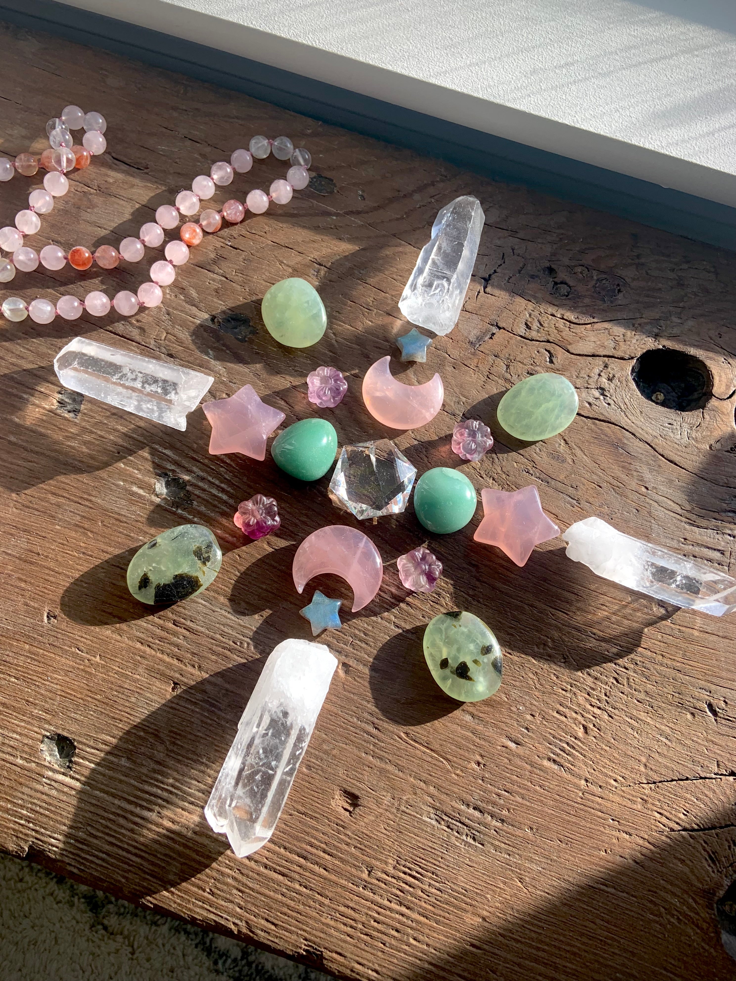 Crystal grid with large Clear Quartz hexagon centerpiece, surrounded by rose quartz moons and stars, prehnite tumbles, labradorite stars, fluorite flowers, and lemurian quartz points