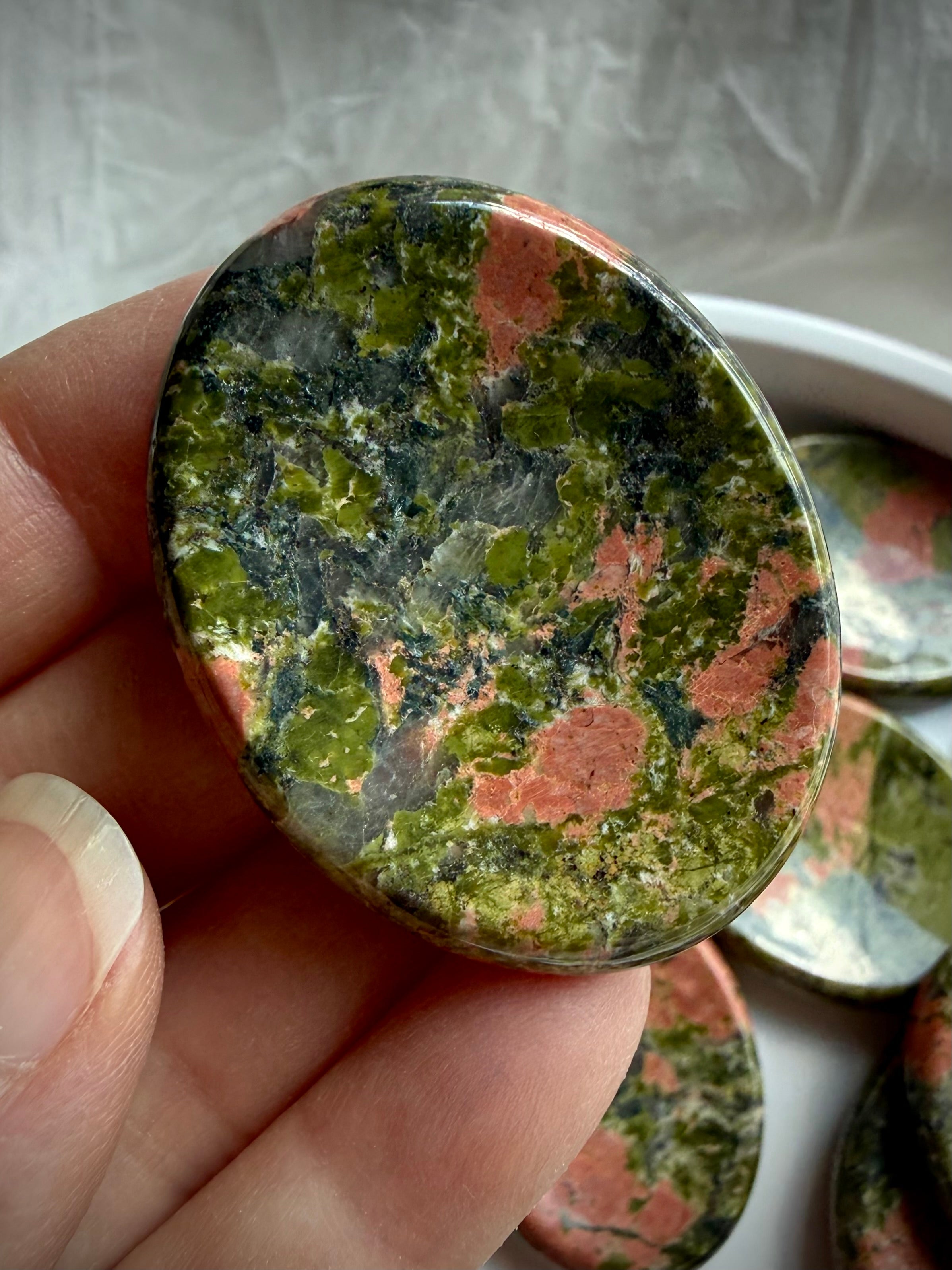 unakite palm stone held in hand for grounding energy compassion and inner balance