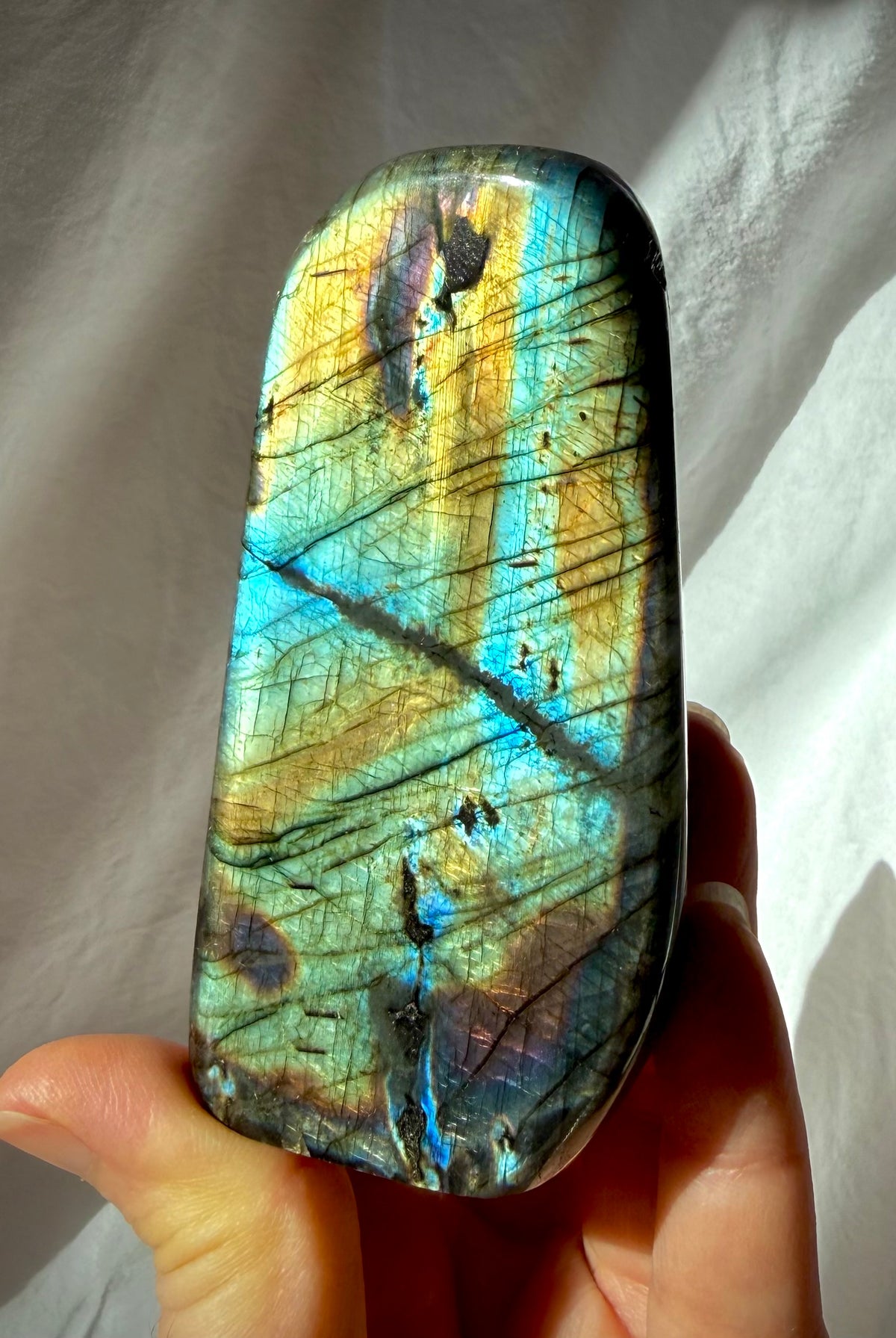 Labradorite crystal freeform with luminous gold, aqua, green, and blue flash across the polished face