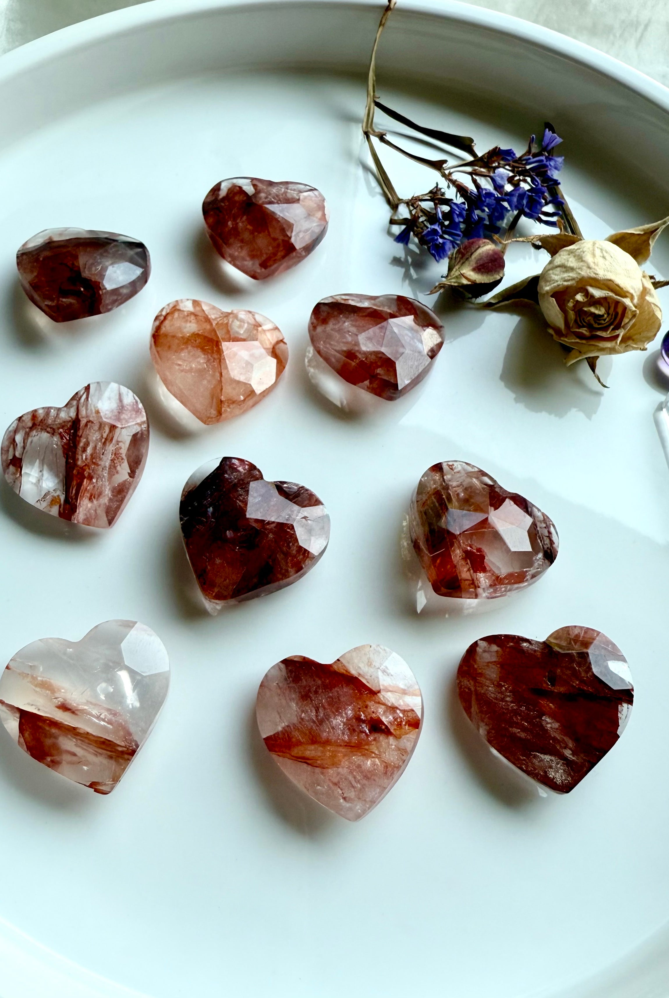 Array of faceted Fire Quartz hearts – natural hematoid quartz carvings showing red hematite inclusions