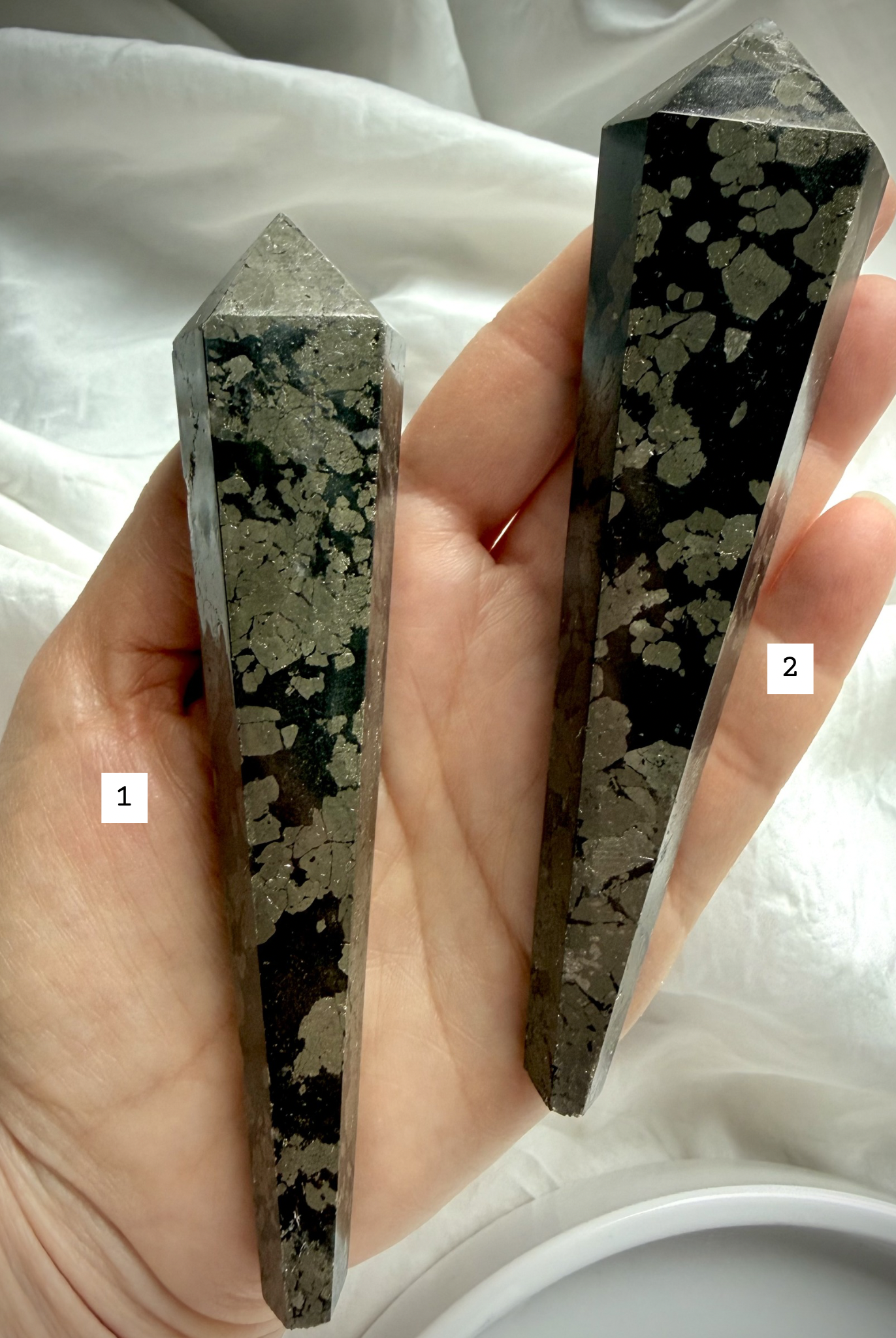 pyrite wand in black matrix options labeled held in hand polished crystal points for selection