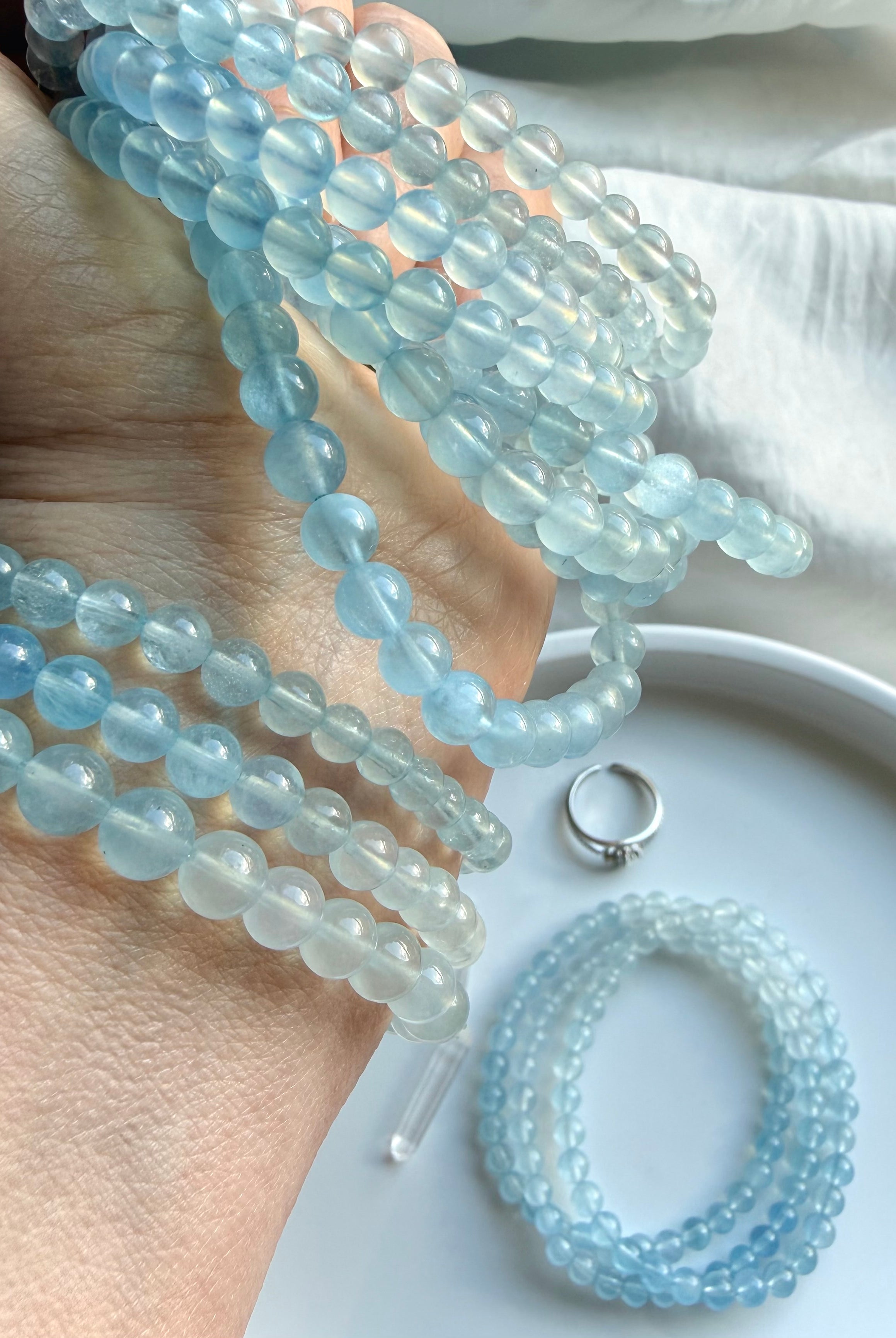 Aquamarine beaded bracelet stack on wrist – March birthstone blue crystal stretch bracelets
