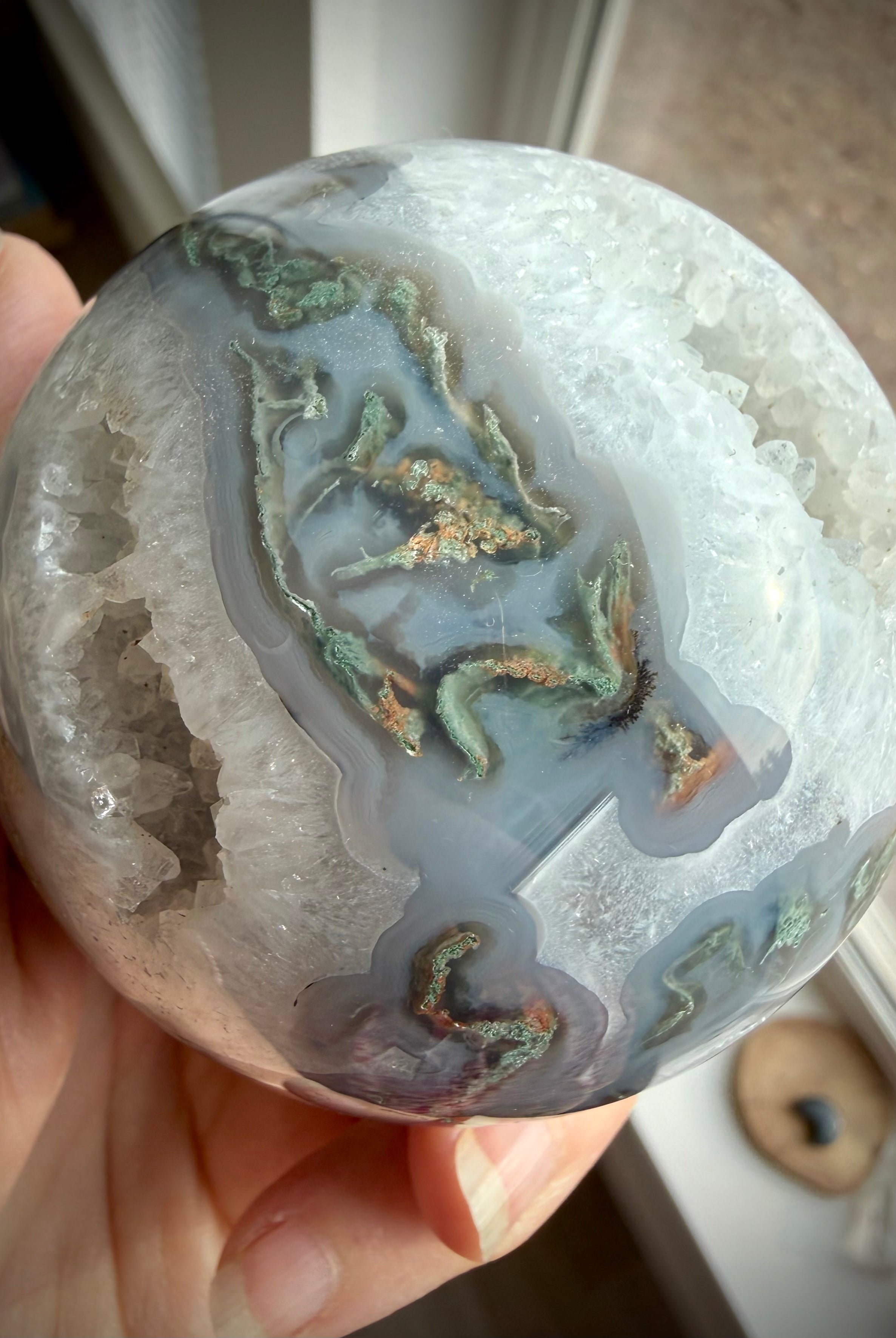Moss Agate crystal ball with natural Quartz geode, intricate green dendrites and layered blue-gray chalcedony patterns