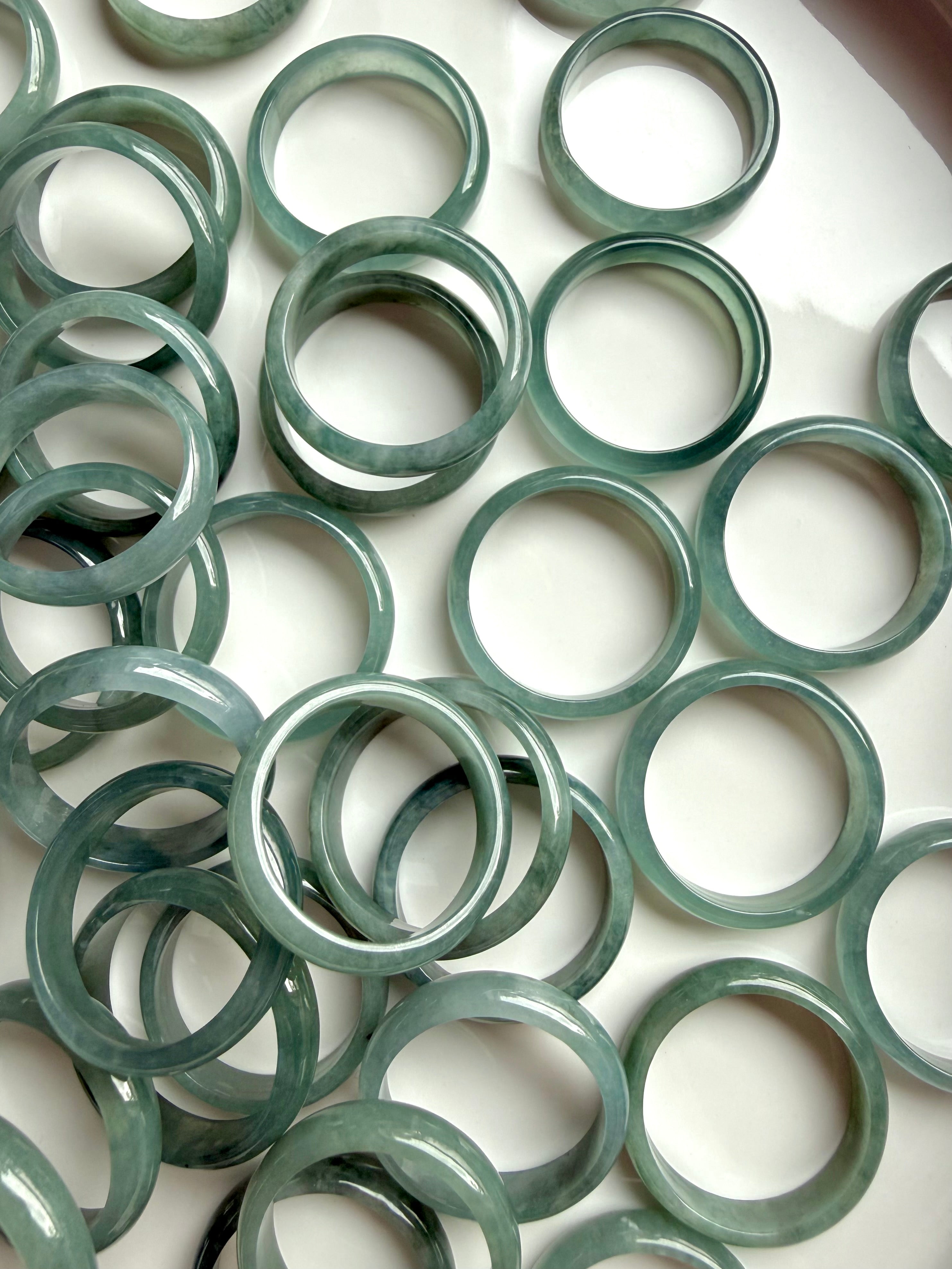 Full tray of rounded Blue Water jadeite band rings, natural jade crystal ring assortment