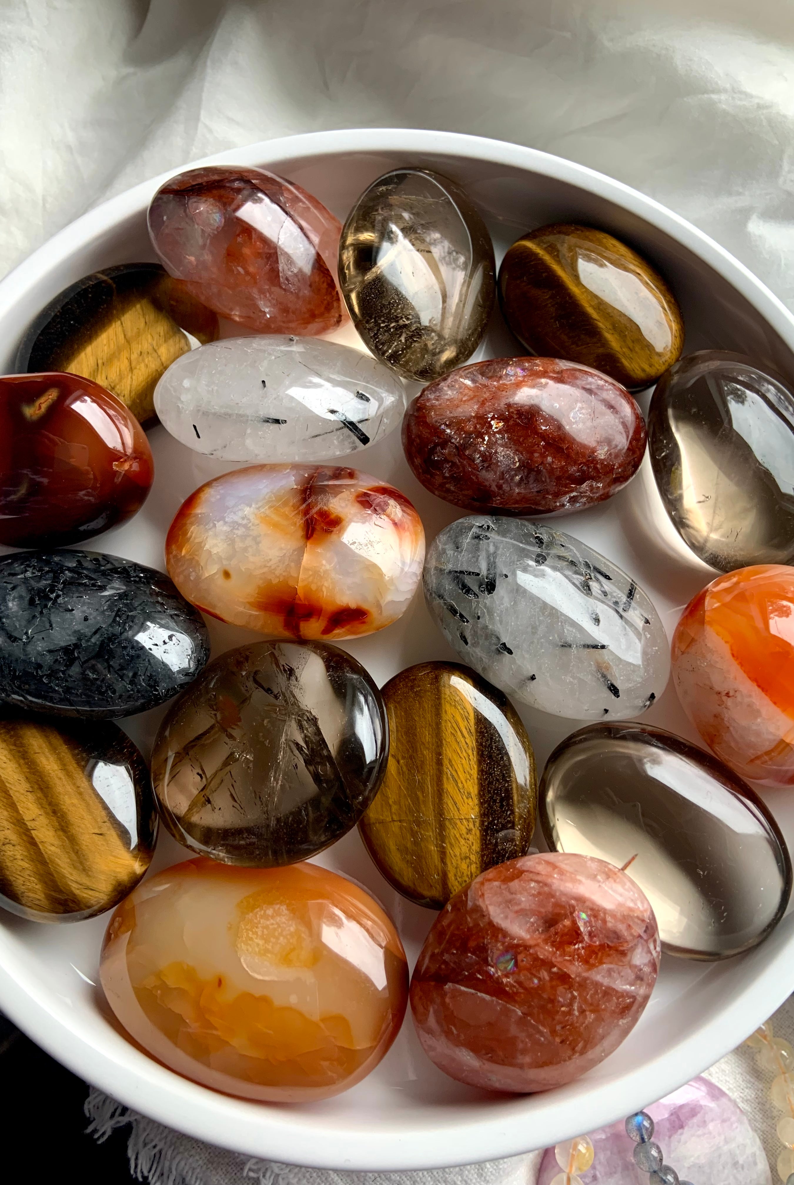 Assorted chakra palm stones in warm, earthy tones — grounding crystals for Root, Sacral & Solar Plexus chakra alignment and energy healing.