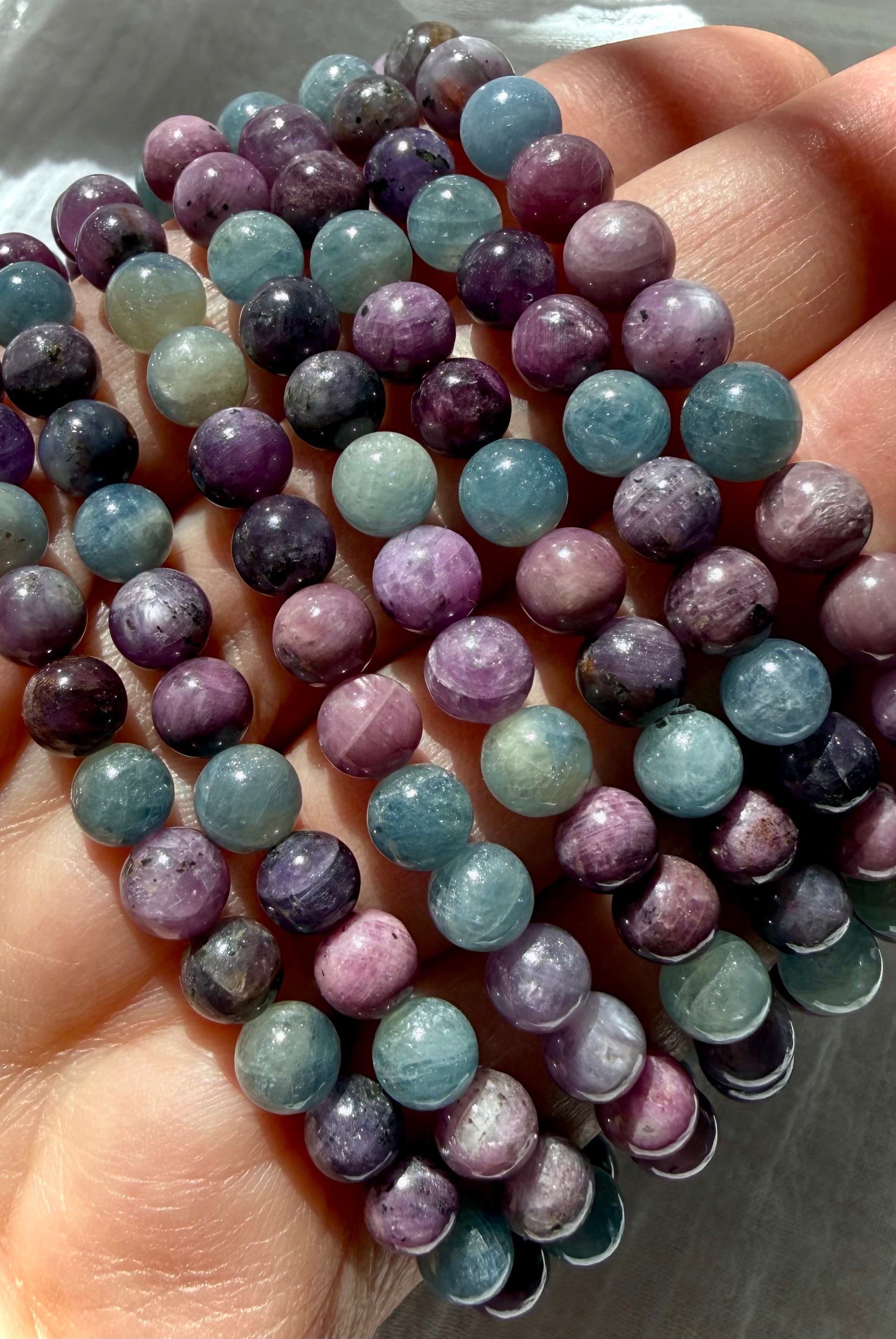 closeup of Ruby Sapphire crystal bead bracelets highlighting natural ruby and sapphire color variation