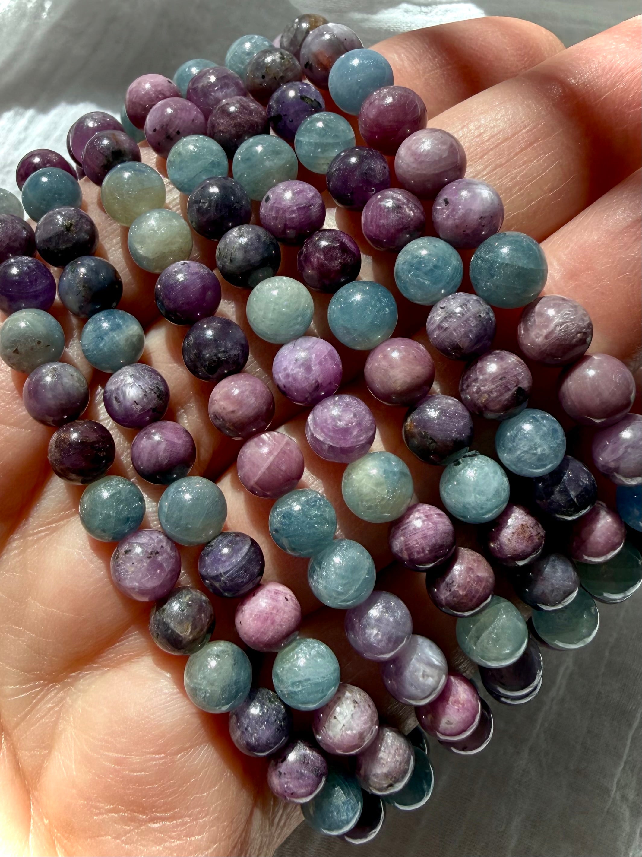 closeup of Ruby Sapphire crystal bead bracelets highlighting natural ruby and sapphire color variation