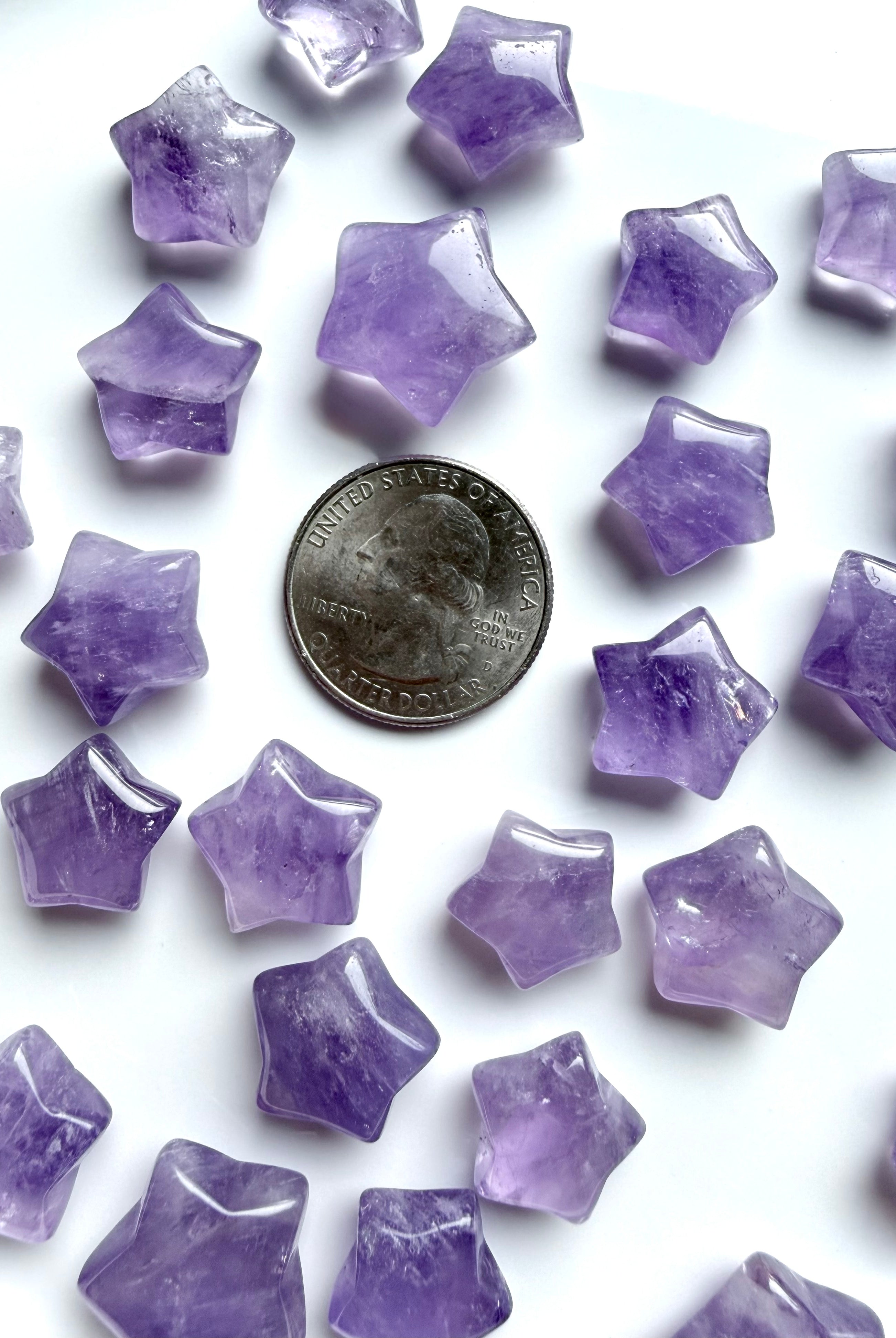 Mini Amethyst star carvings shown with quarter for size reference, small polished crystal stars for grids and pocket stones