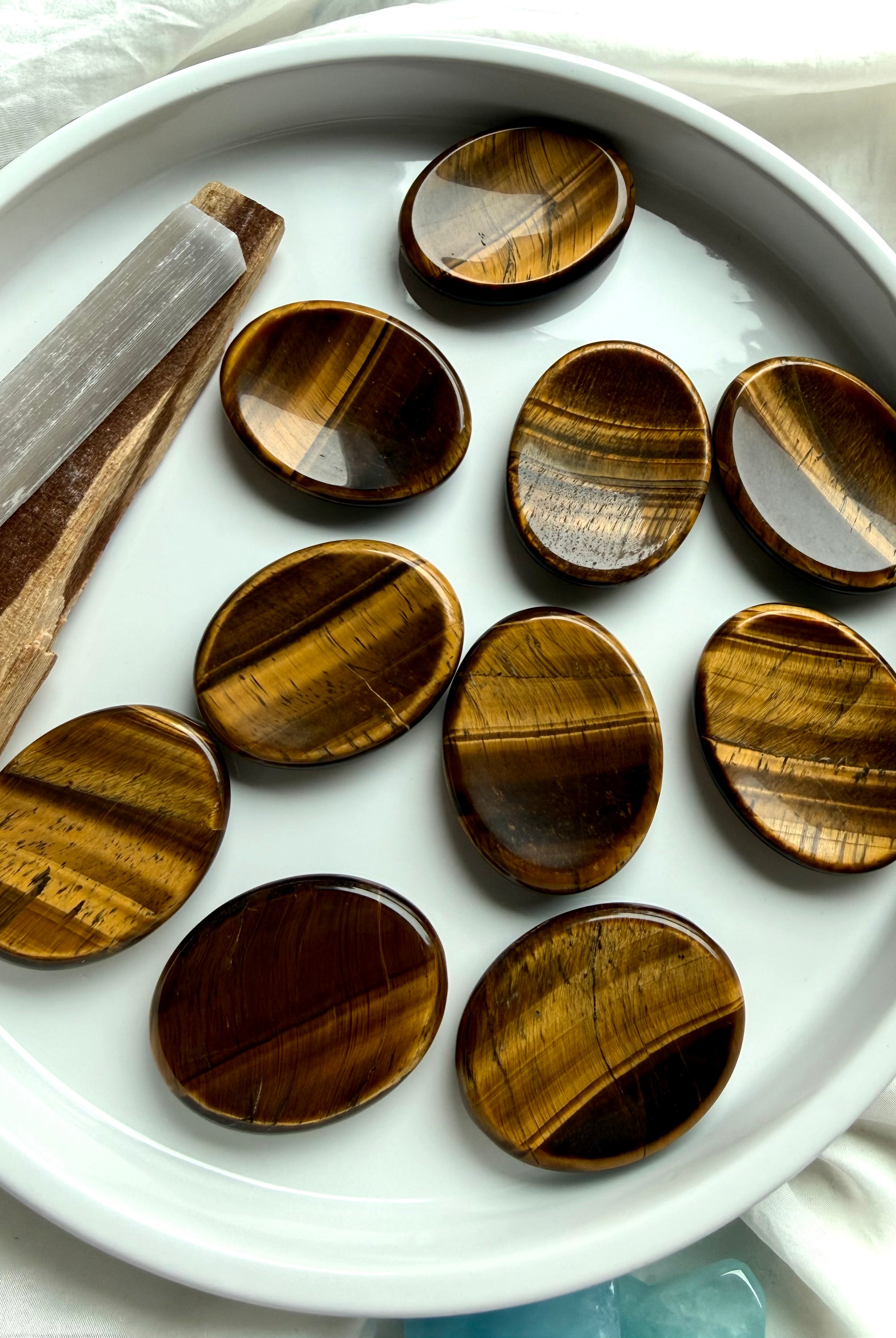 tiger’s eye oval worry stones arranged in ceramic dish, polished thumb stones for protection focus and personal power