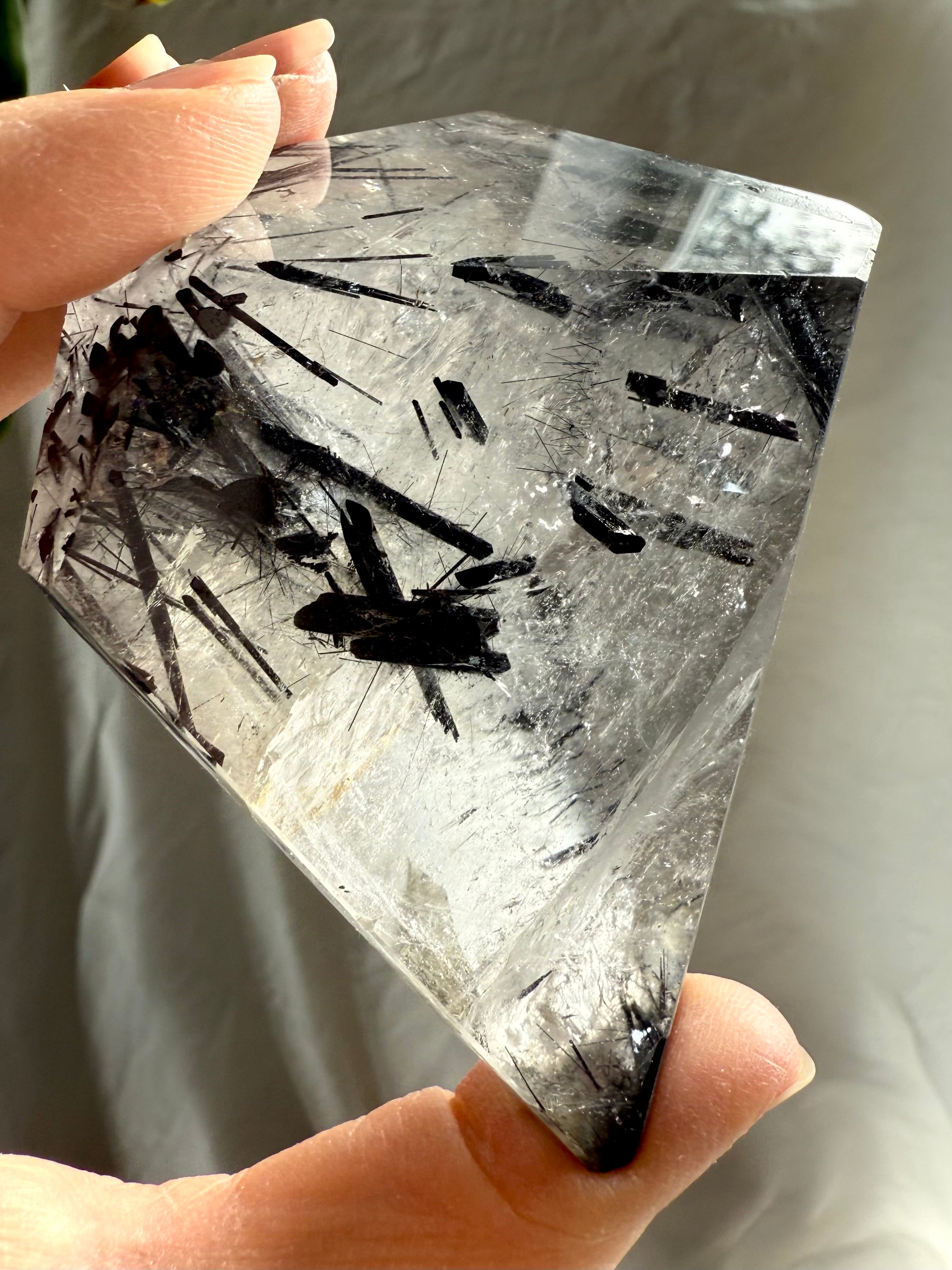 Handheld Black Tourmaline in Quartz freeform showing dark tourmaline needles in clear quartz matrix