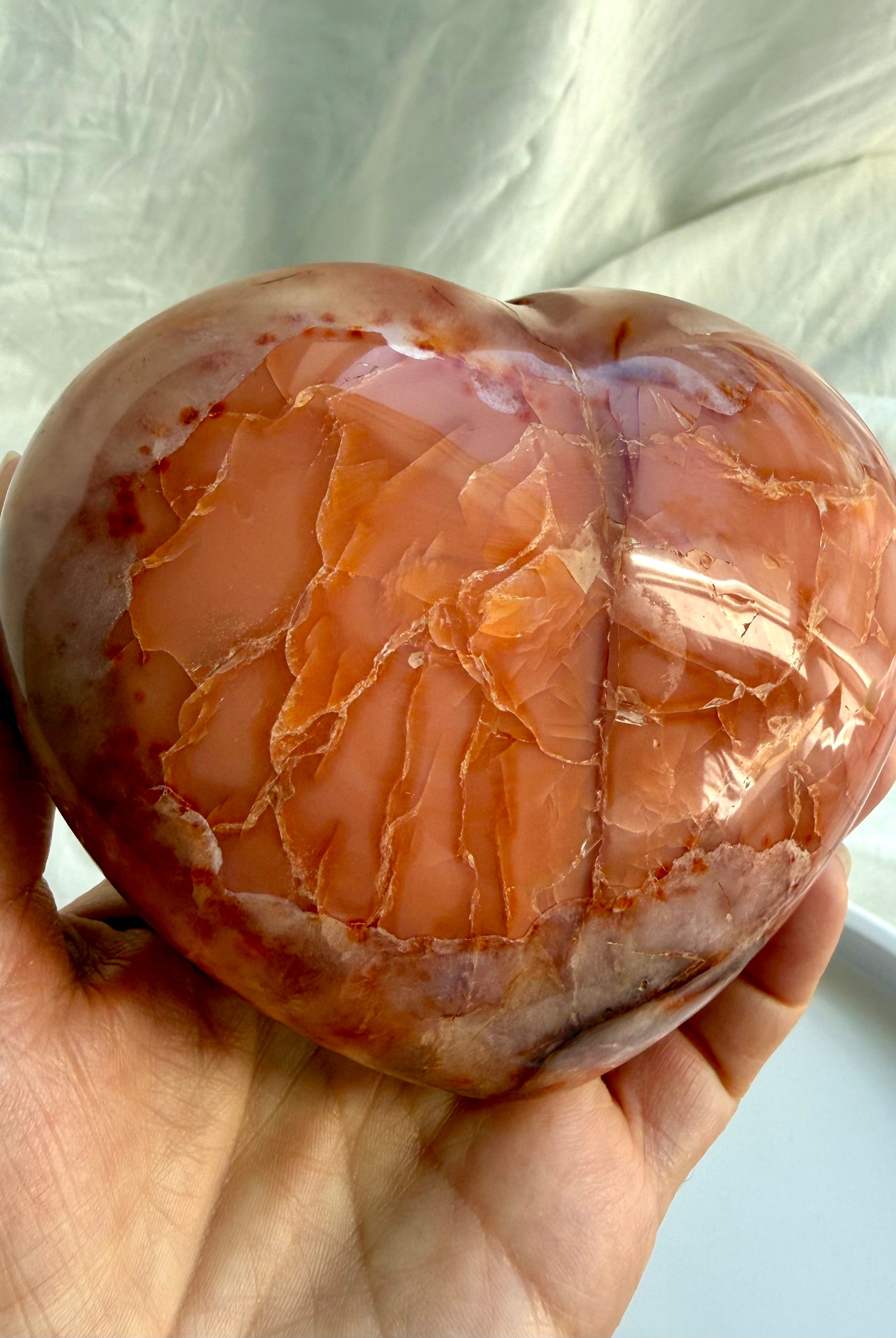 Large Carnelian geode heart held in hand, highlighting depth and polished finish
