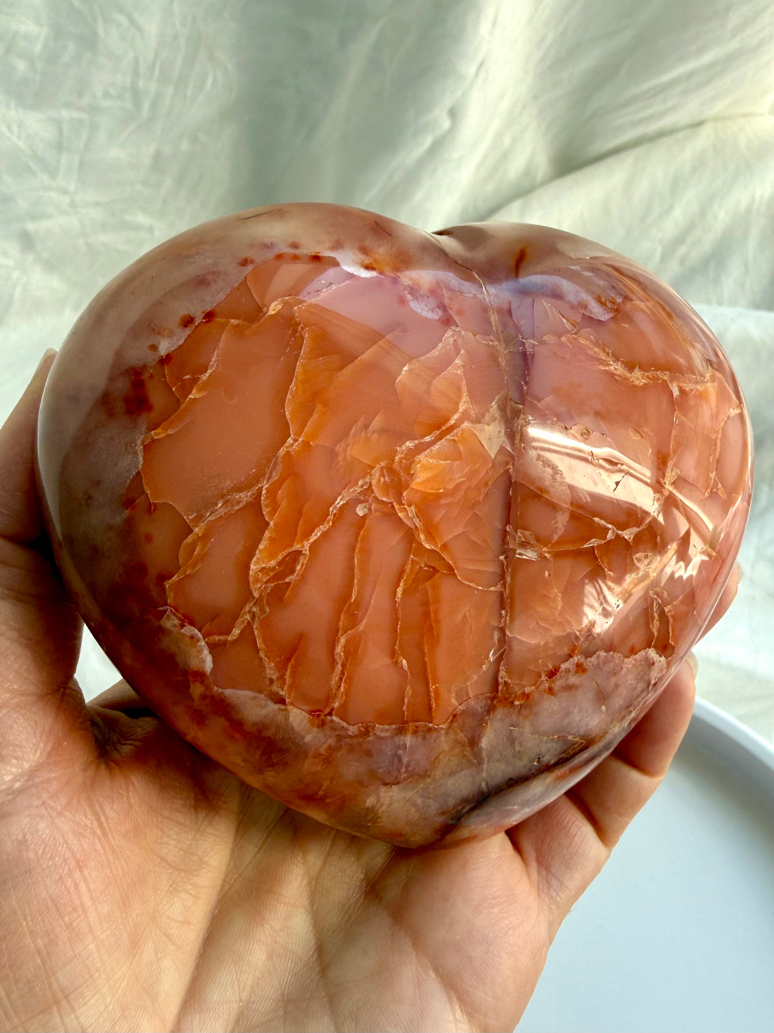 Large Carnelian geode heart held in hand, highlighting depth and polished finish