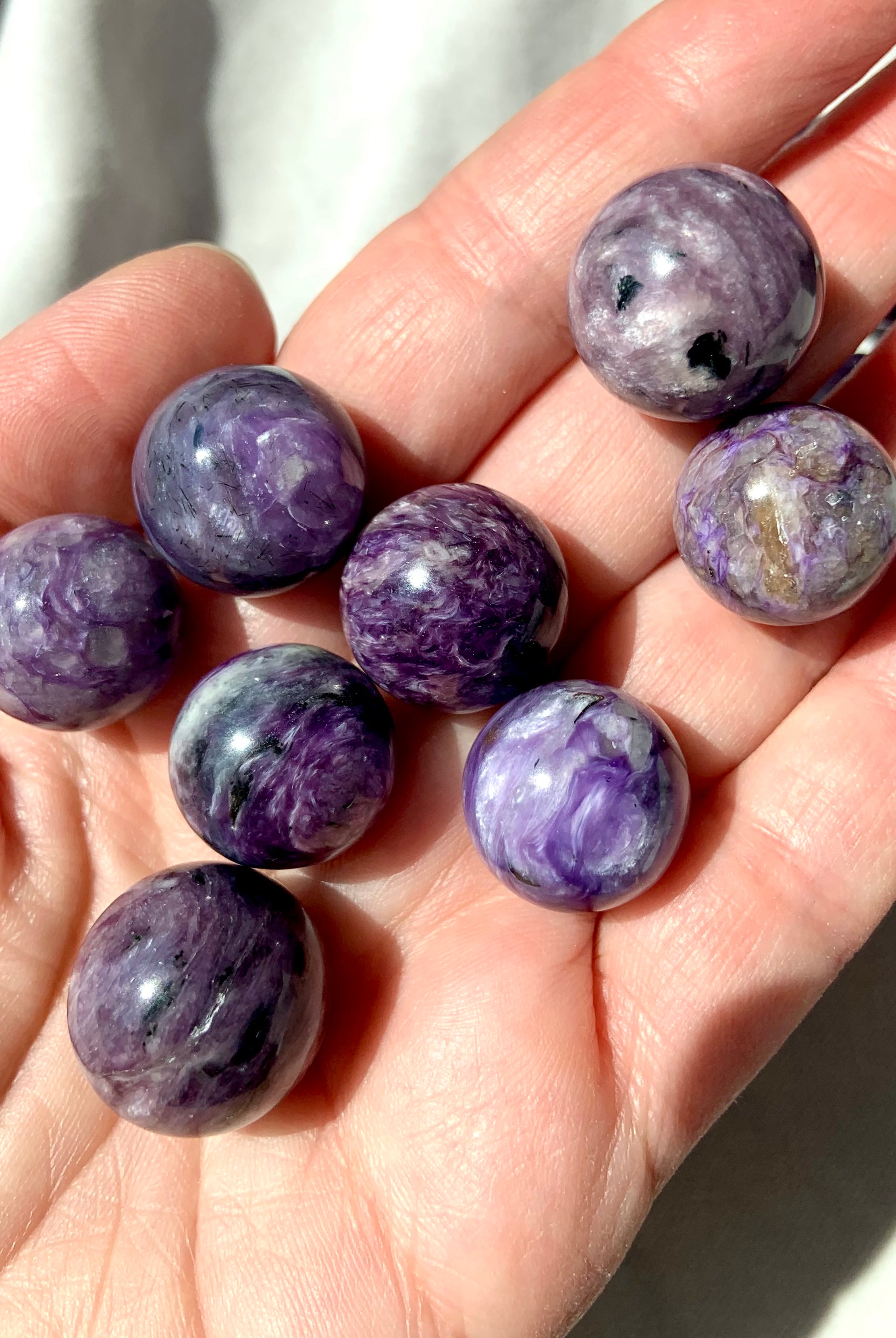 Purple Charoite mini spheres shown on my hand for scale