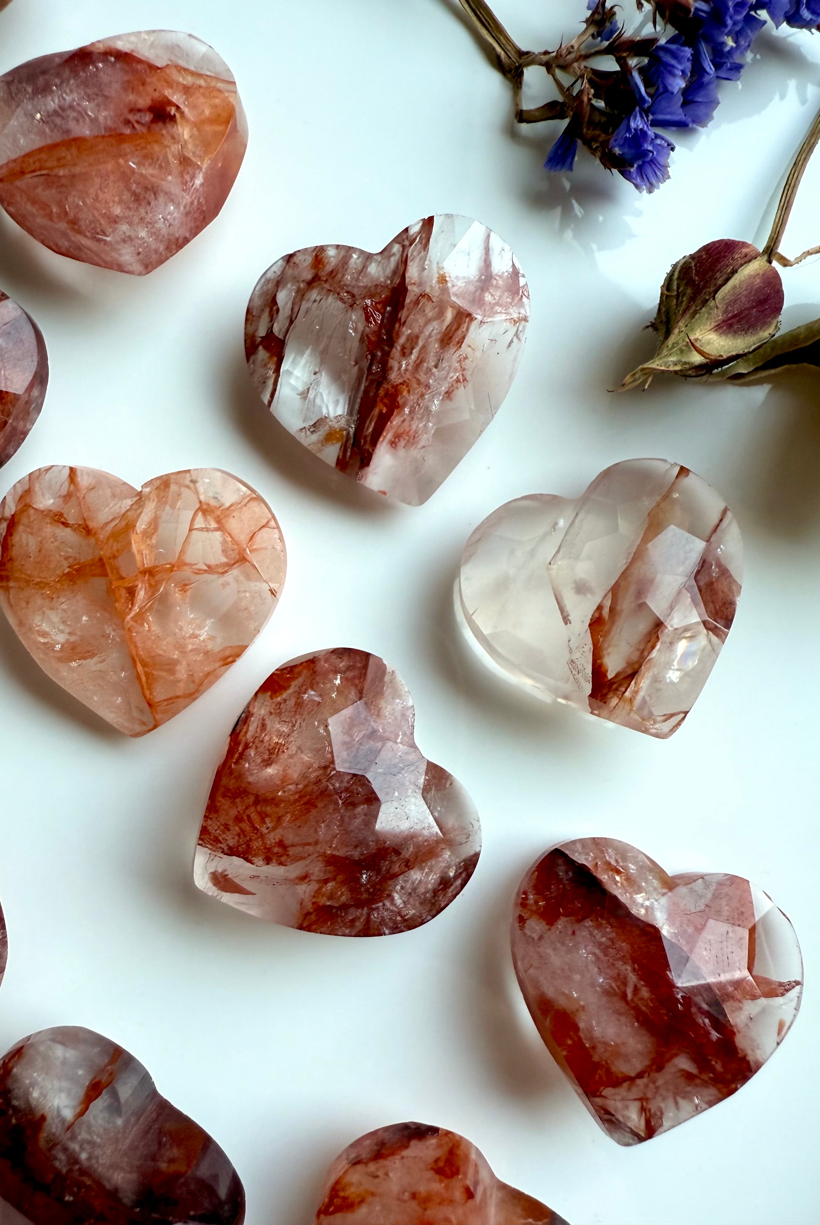 Closeup of Fire Quartz faceted heart carvings on white background – mini crystal for Root Chakra support
