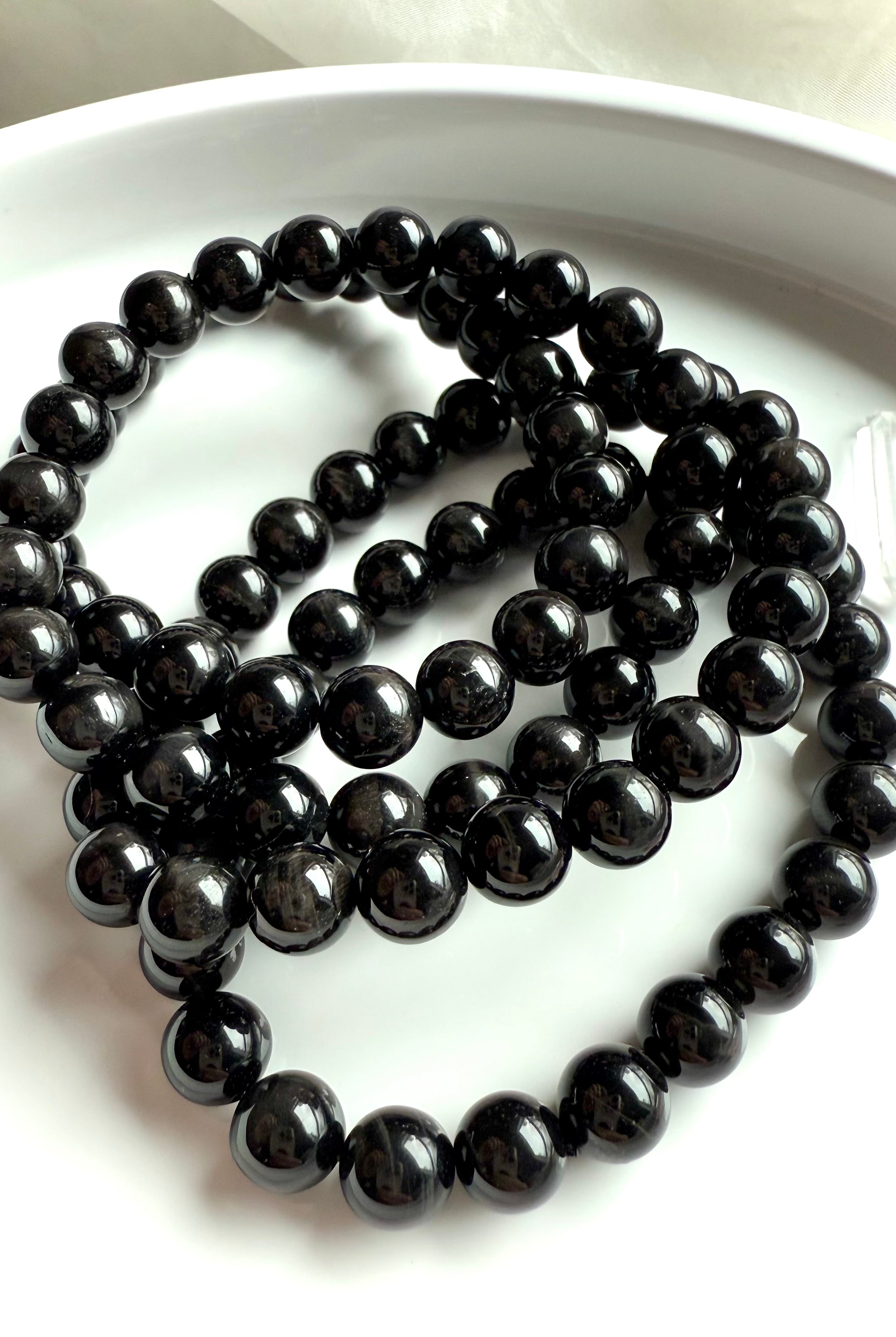Black Tigers Eye Bracelet made from glossy black beads with tiger eye striations + cat’s eye shimmer