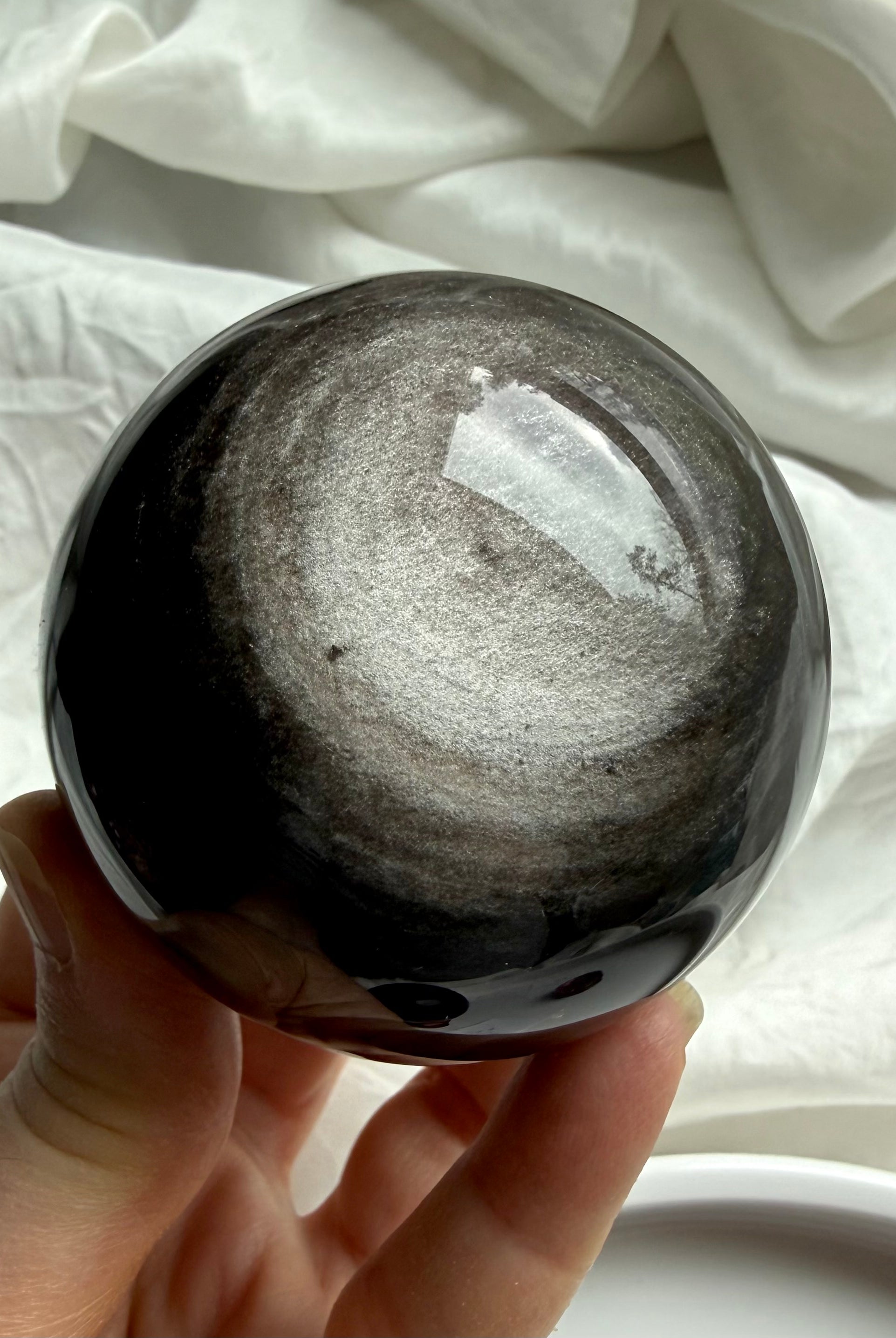 Silver Sheen Obsidian sphere held in hand, a grounding Root Chakra crystal for protection, clarity, and intuitive insight