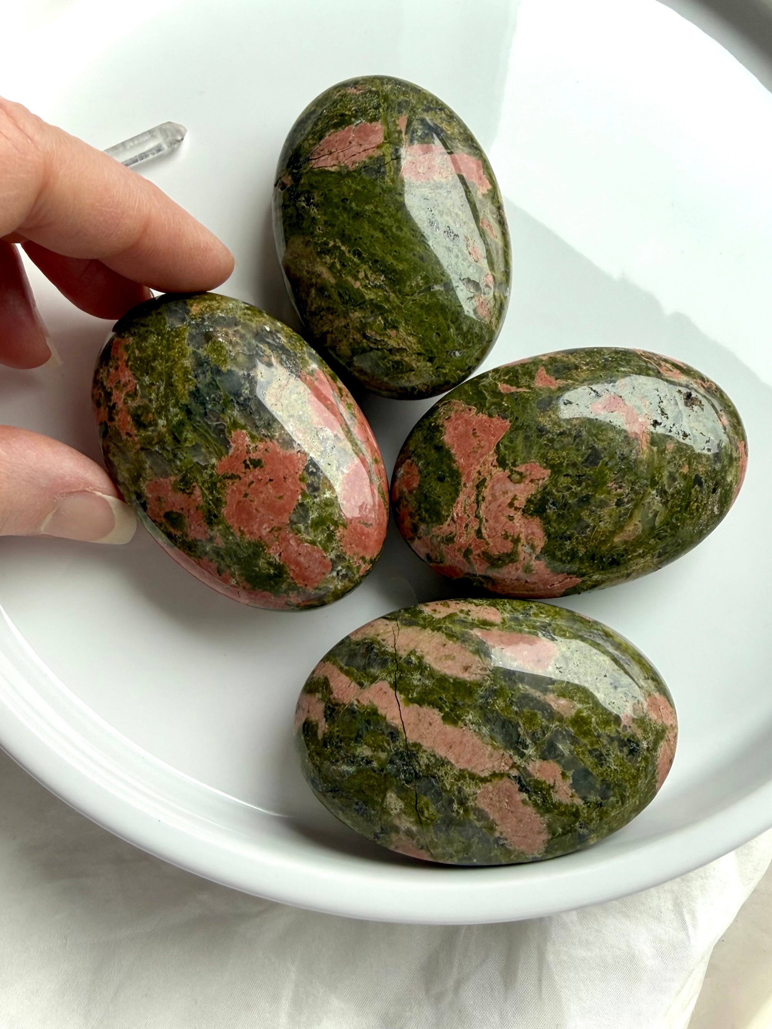 Unakite palm stones on a tray, polished healing crystals for heart chakra love emotional balance and grounding