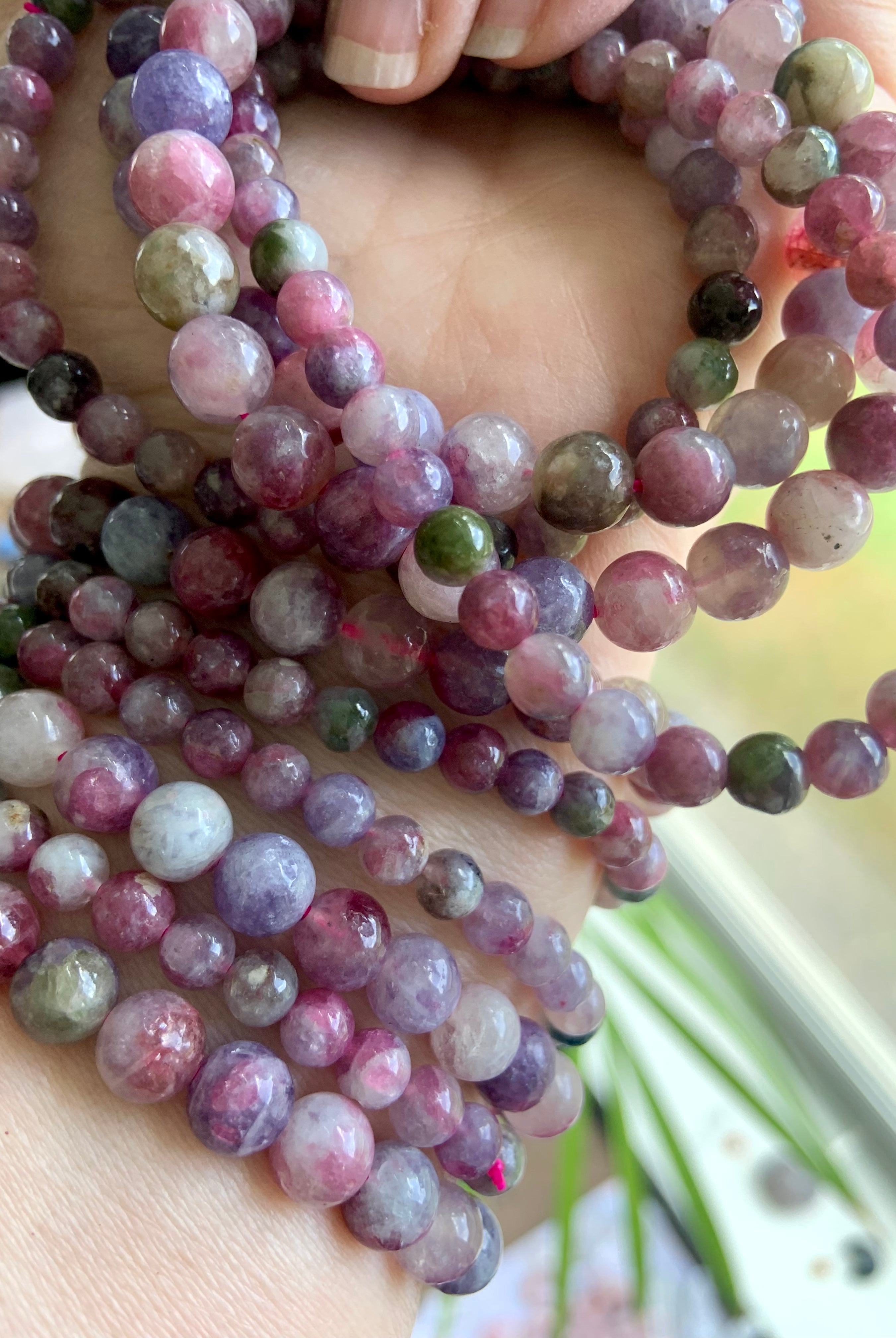 Detailed closeup of Watermelon Tourmaline & Lepidolite beads — colorful heart chakra crystals showing natural variation in size, texture + hue