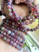 Detailed closeup of Watermelon Tourmaline & Lepidolite beads โ colorful heart chakra crystals showing natural variation in size, texture + hue