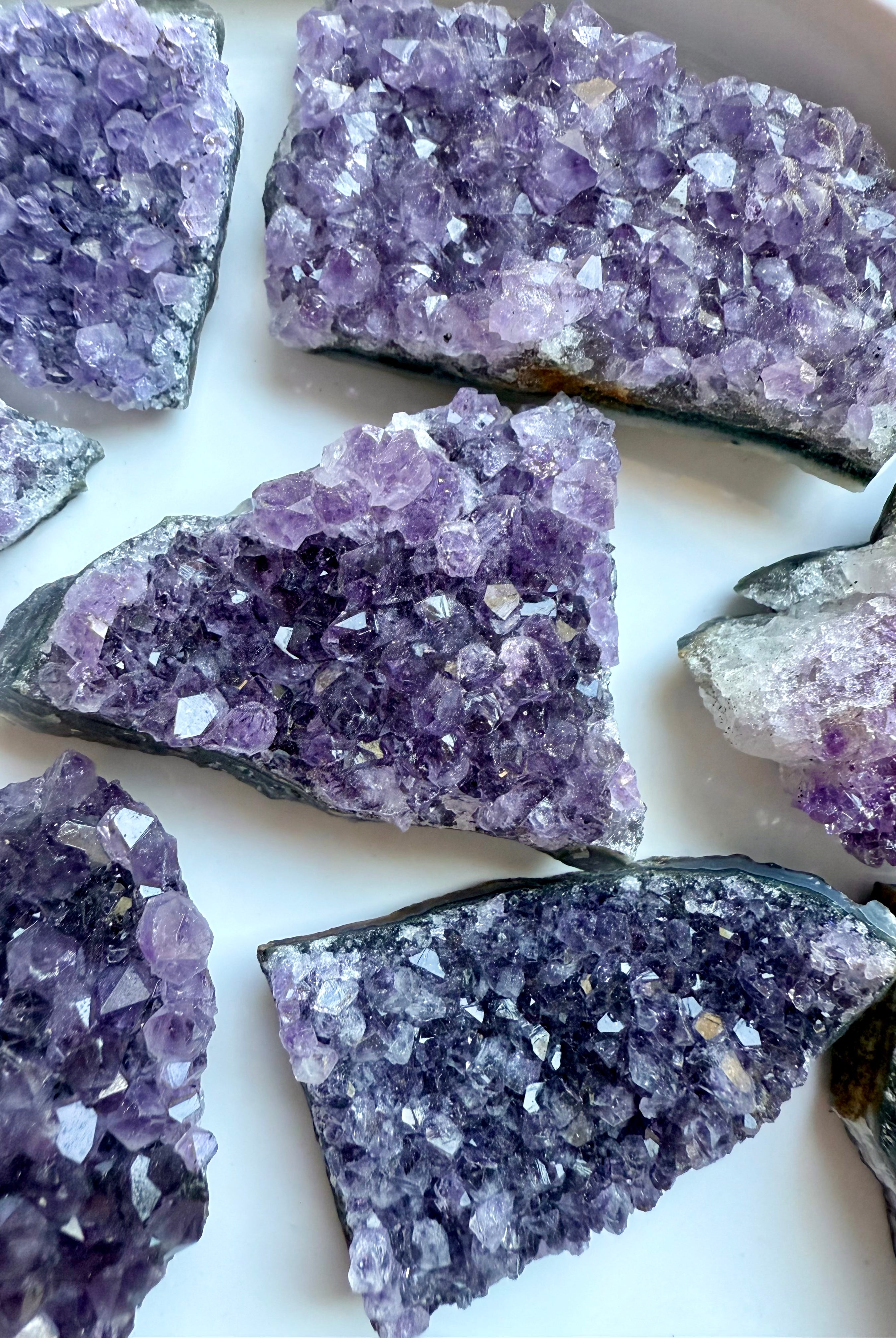 Amethyst geode clusters with raw edges and glittering purple points. Crown Chakra crystals for peace, grounding, and spiritual protection.