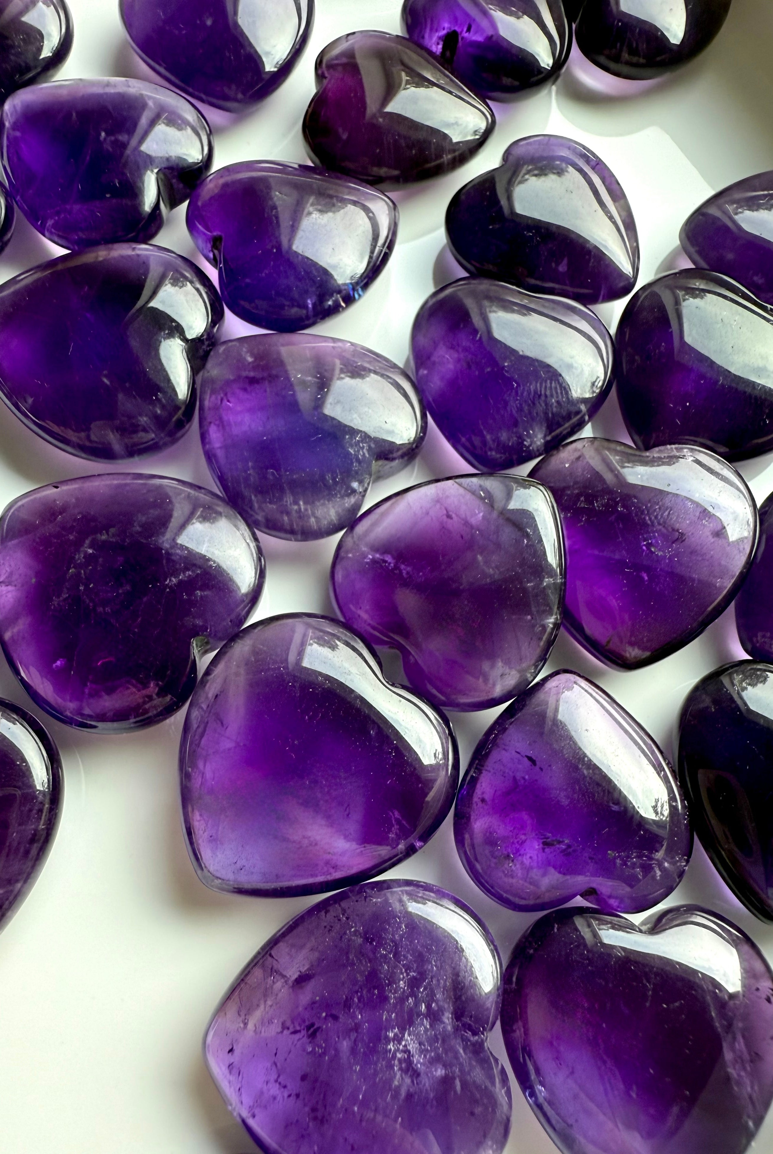 Assorted Amethyst crystal hearts with rich violet color and natural inclusions — healing crystals for spiritual clarity, intuition, and crown chakra alignment