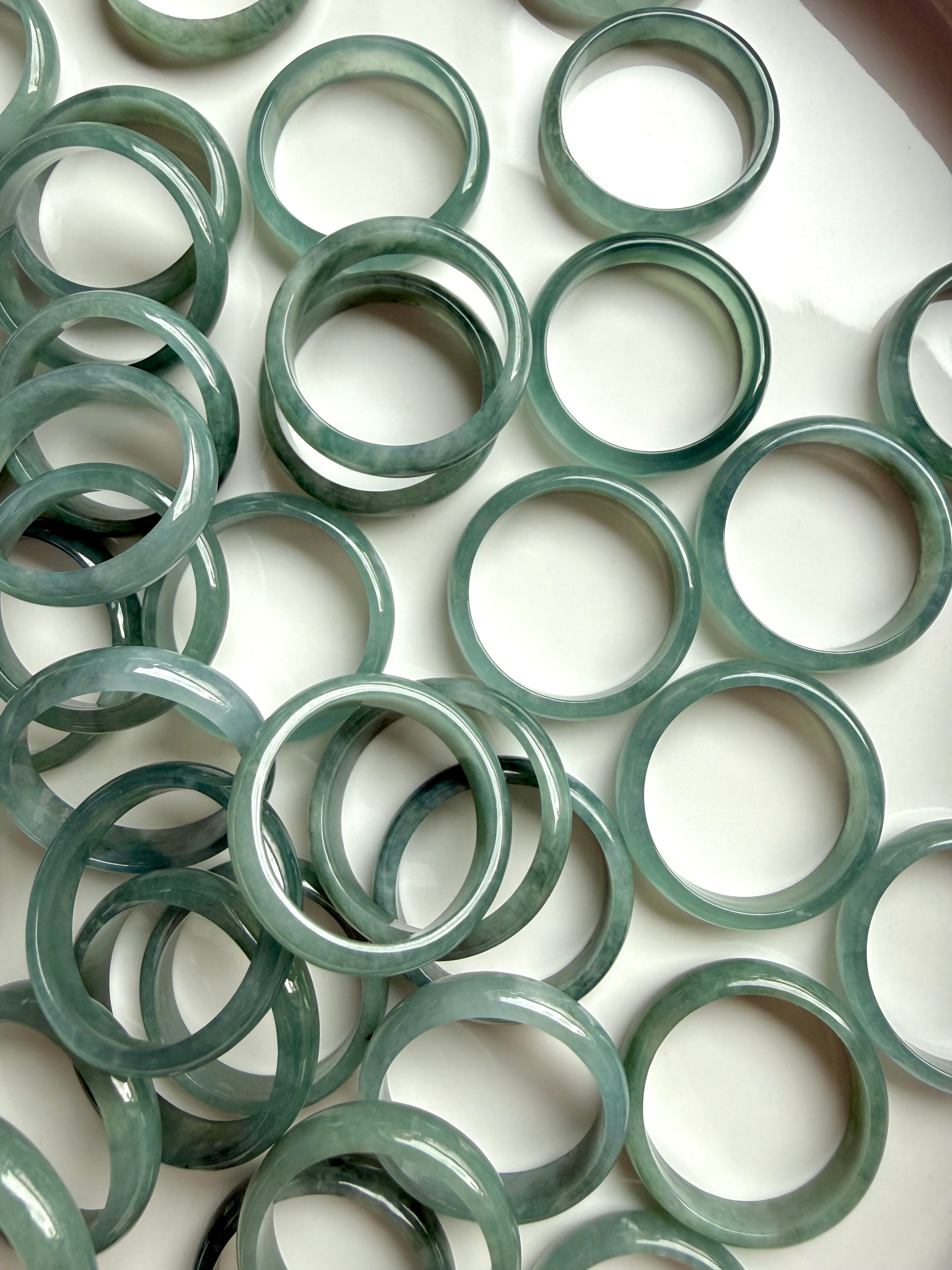 Full tray of rounded Blue Water jadeite band rings, natural jade crystal ring assortment