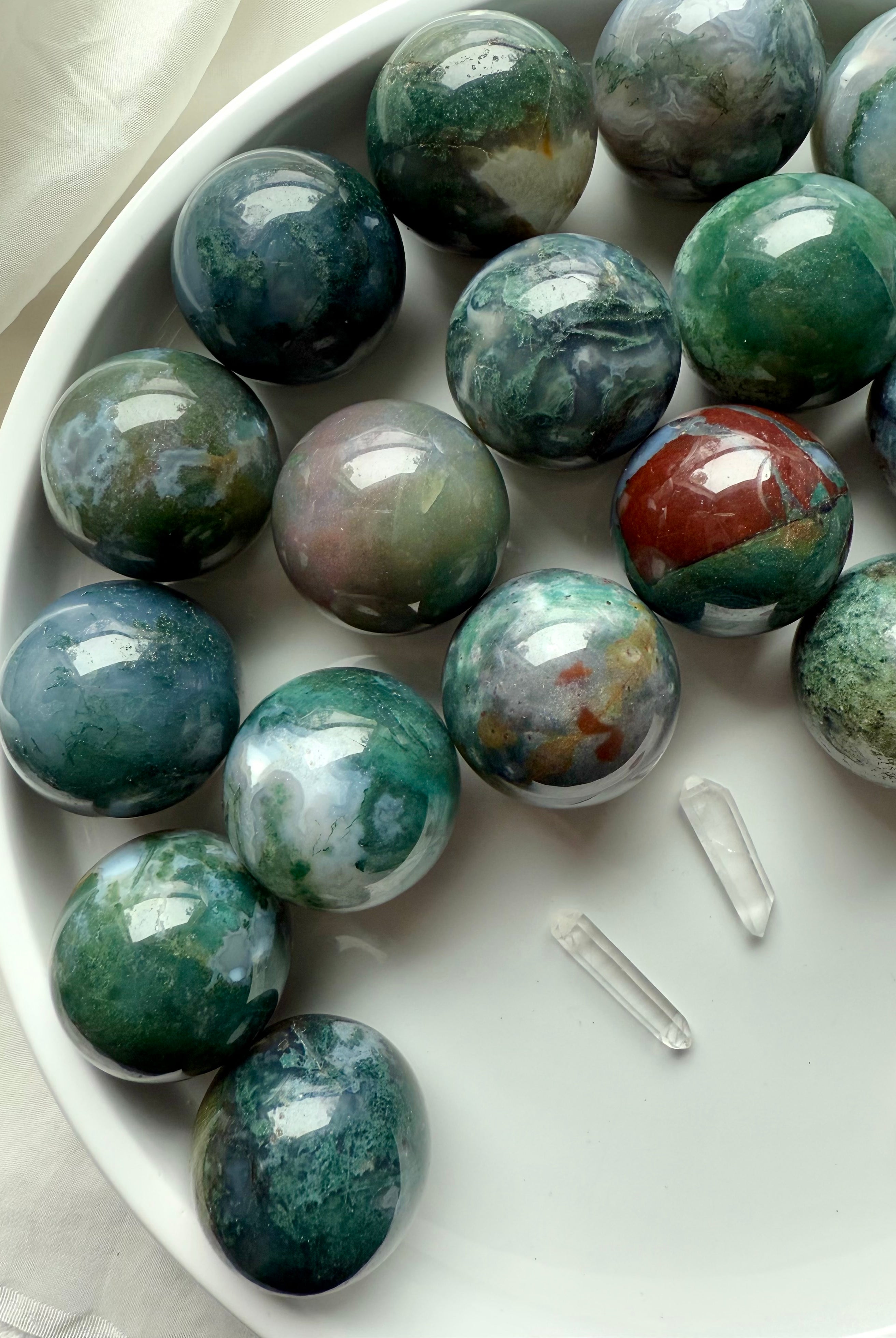 Colorful moss agate mini spheres shown on a white plate