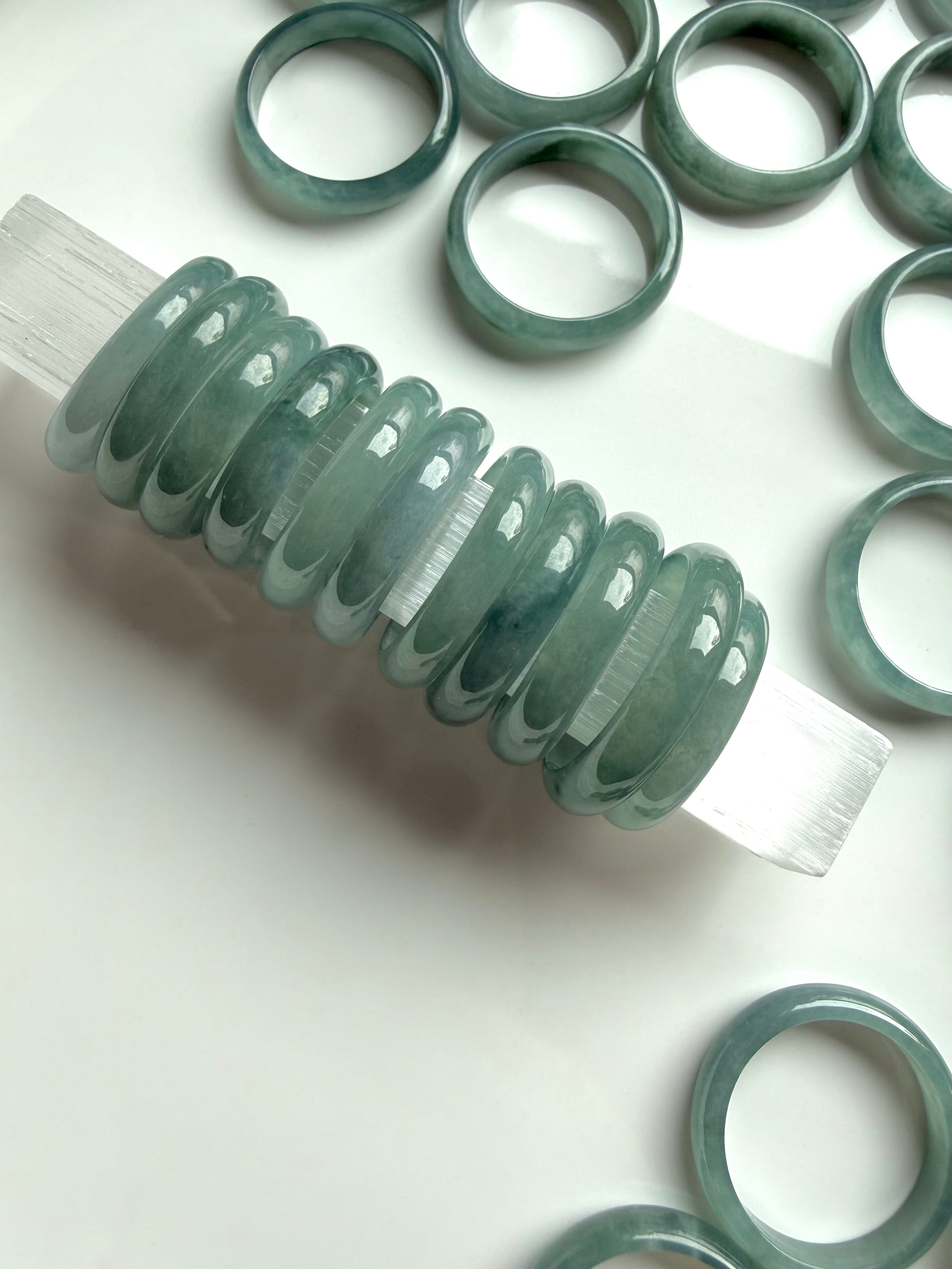 Rounded Blue Water jade rings arranged on white surface, natural Guatemalan jadeite bands