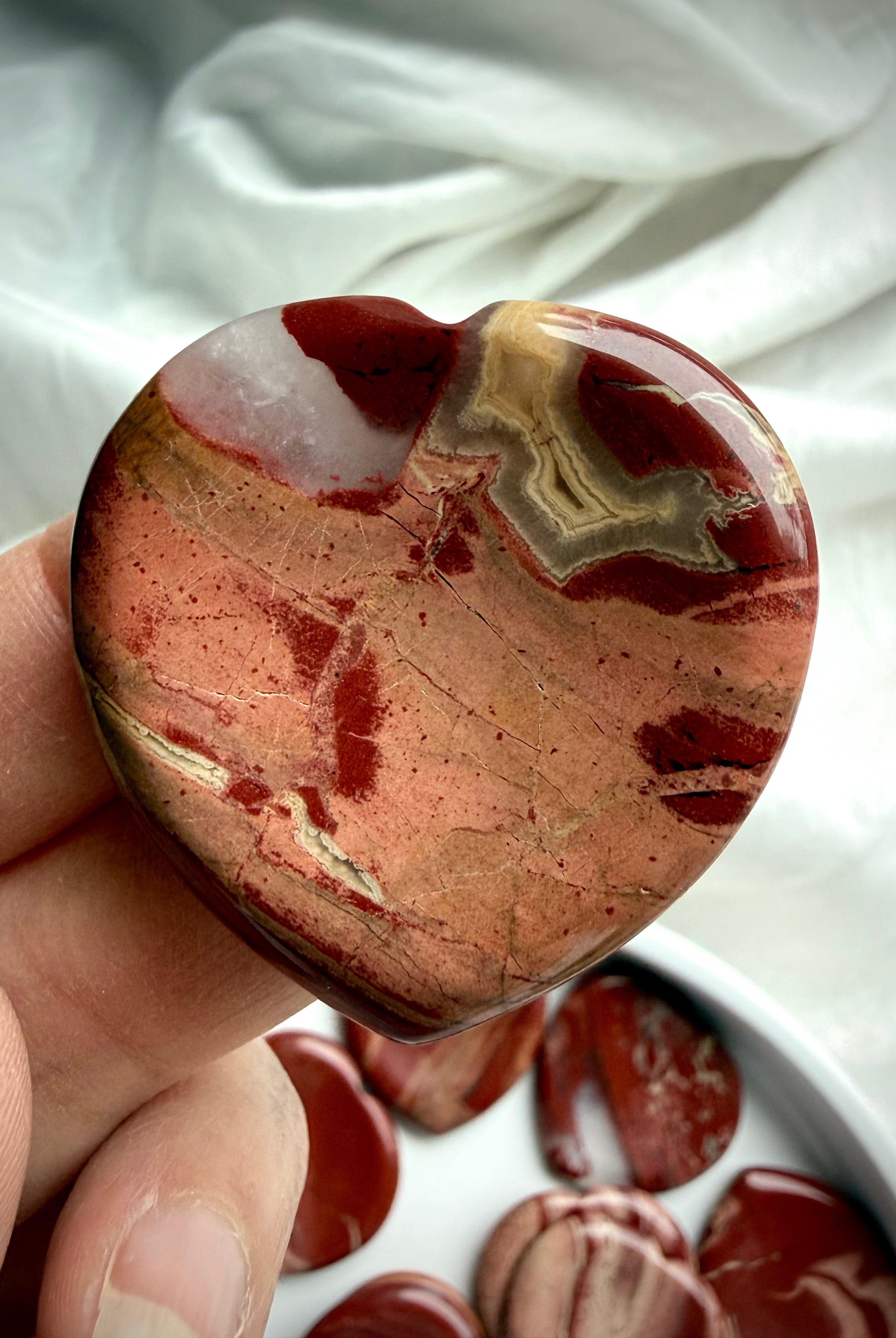 red jasper heart worry stone close up – grounding Root Chakra crystal for strength and balance