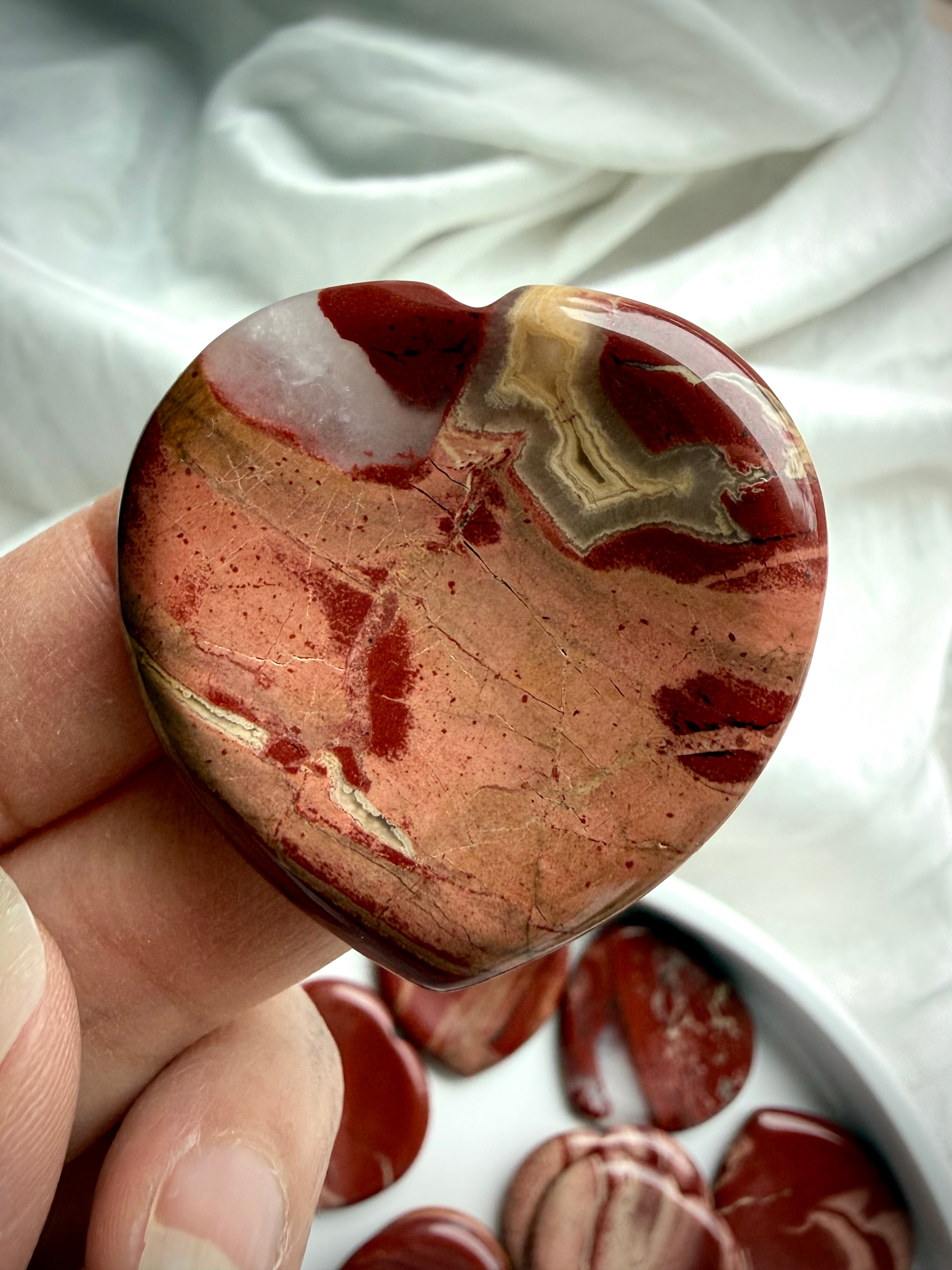 red jasper heart worry stone close up – grounding Root Chakra crystal for strength and balance