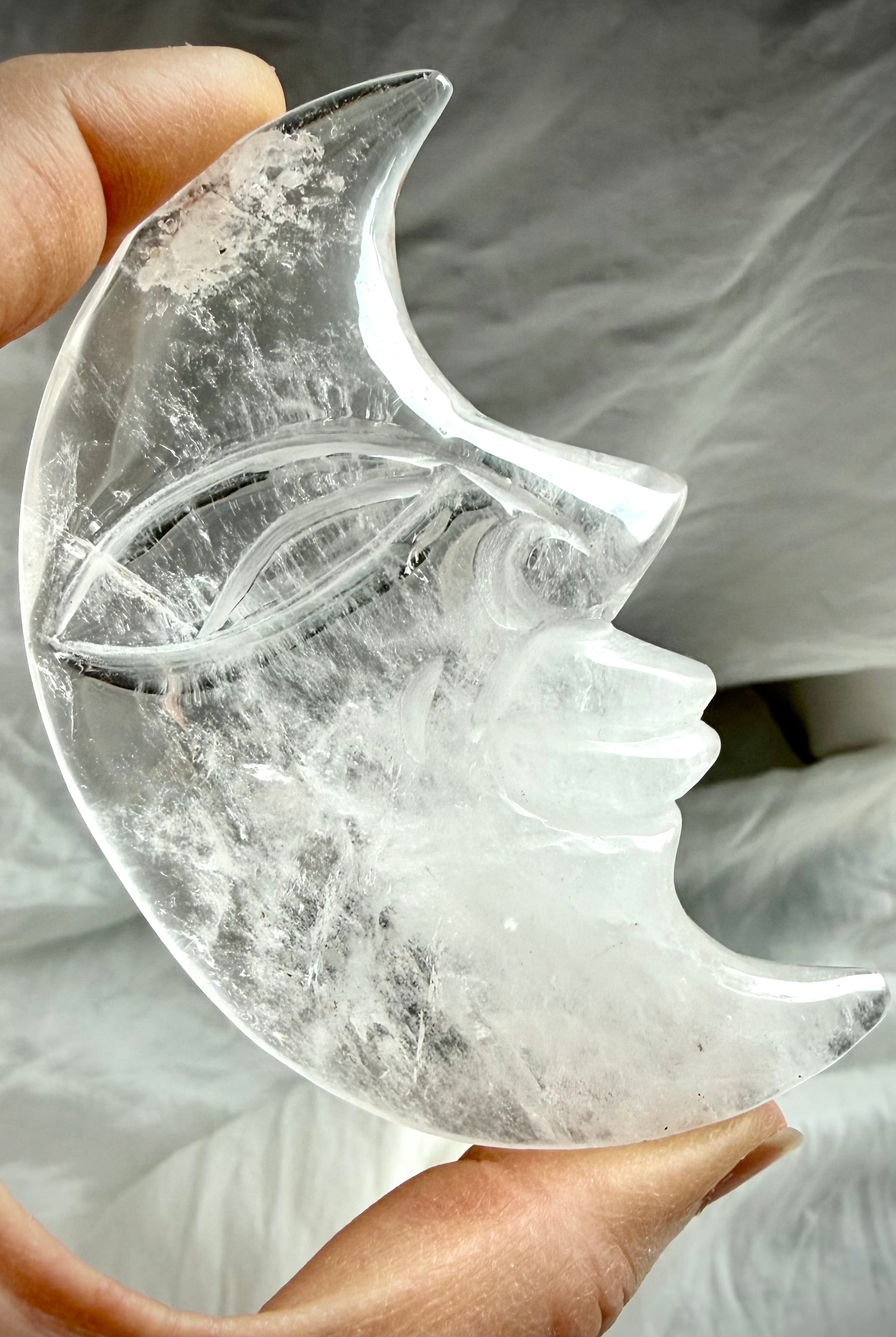 Reverse side of Clear Quartz Moon Face carving showing intricate carving, polished finish, and exceptional crystal clarity